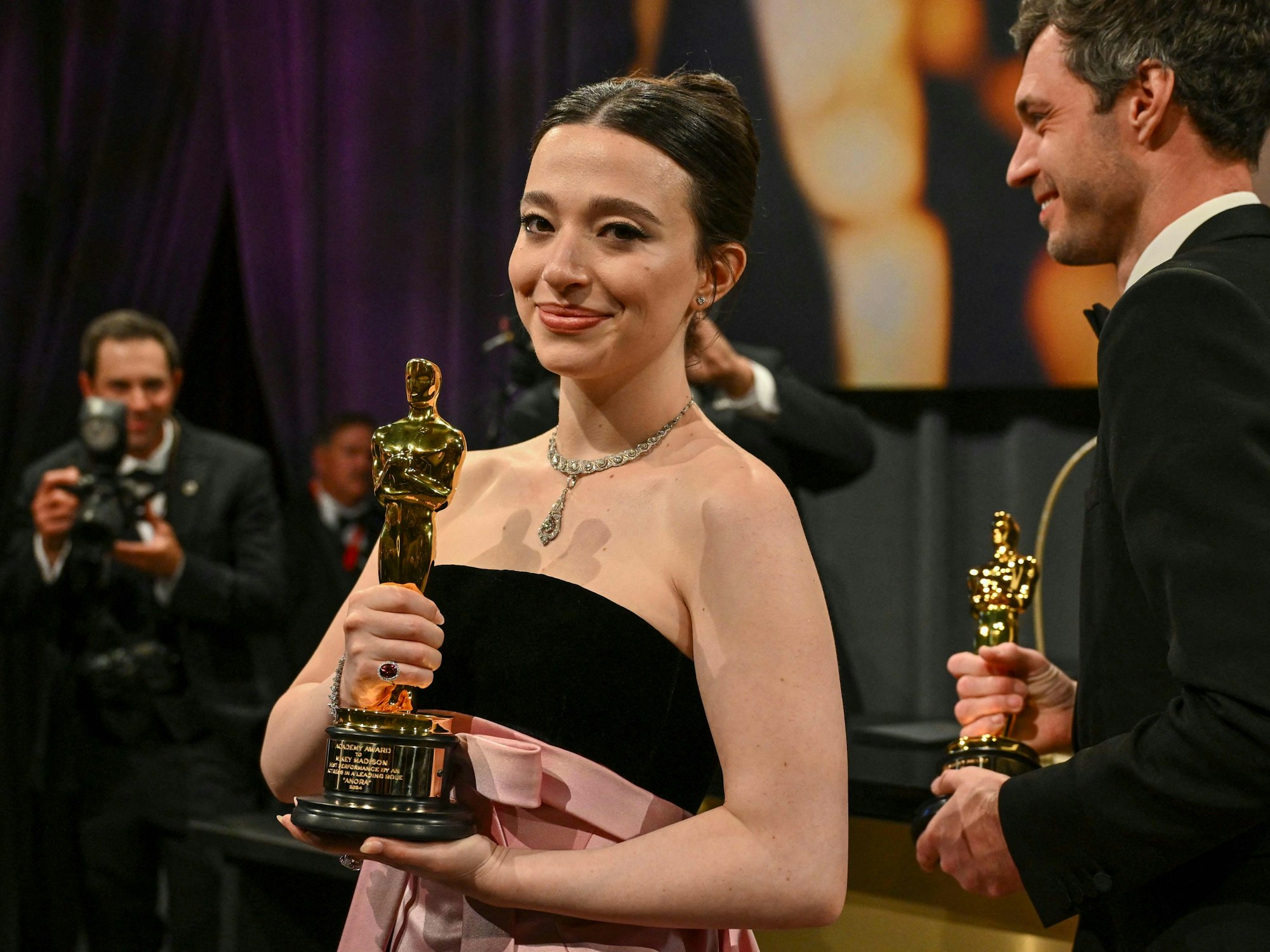 Mikey Madison hält ihre Oscar-Trophäe in die Kameras,