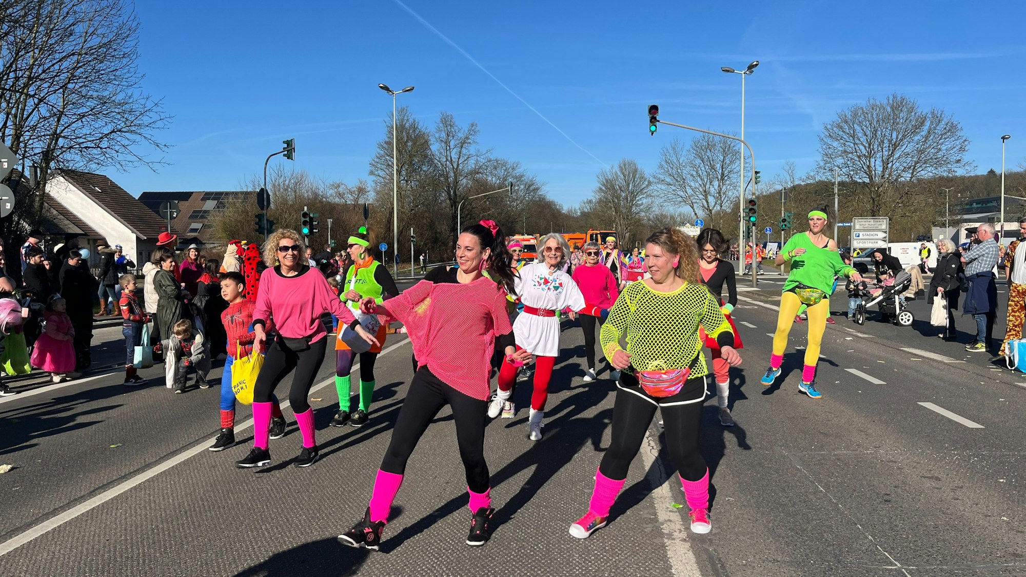 Bunt verkleidete Frauen tanzen auf der Straße Zumba.