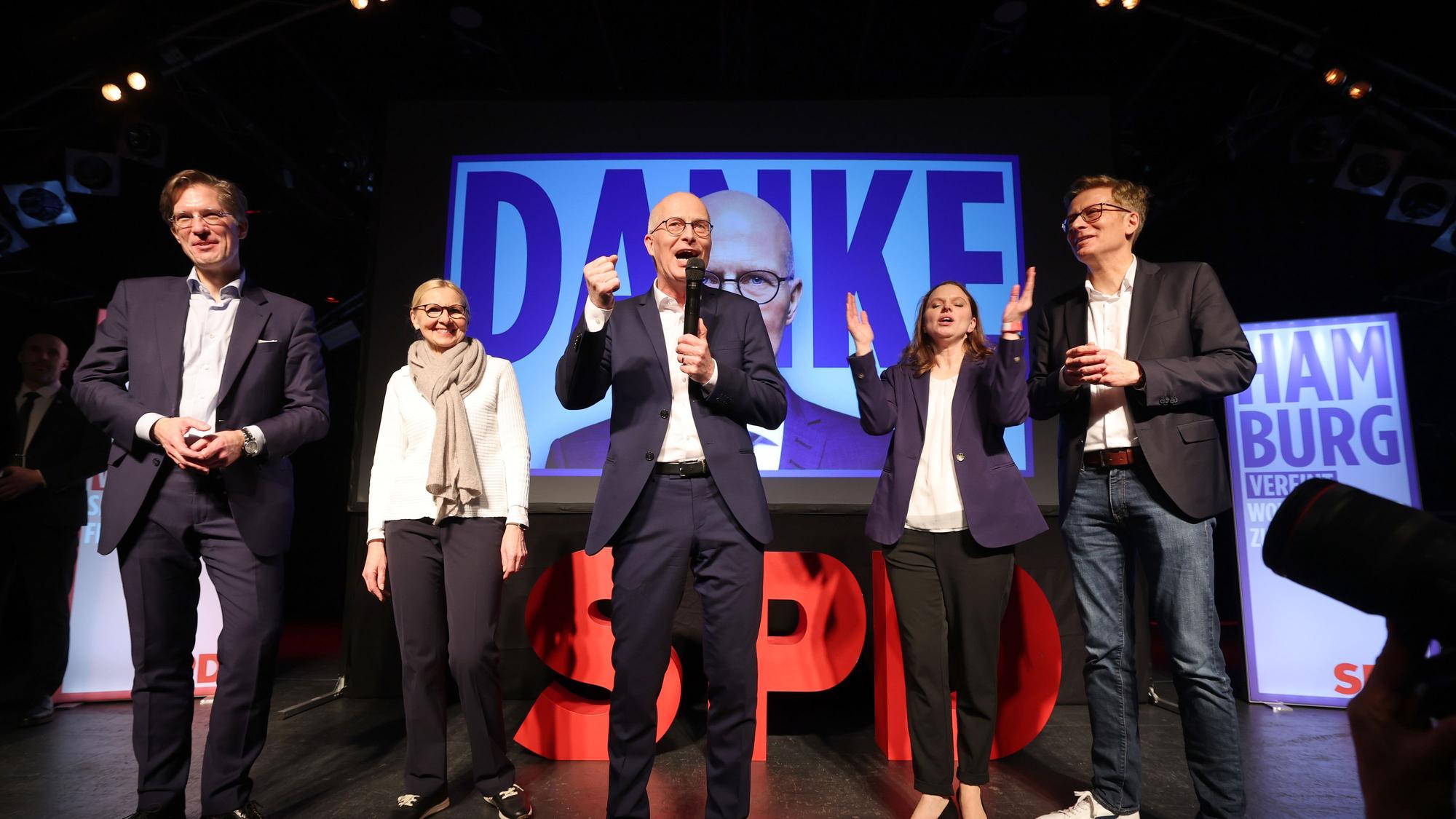 Das Foto zeigt Peter Tschentscher (M, SPD), Erster Bürgermeister von Hamburg, und seine Ehefrau Eva-Maria Tschentscher, Melanie Leonhard (2.vr), Vorsitzende der SPD Hamburg, und Nils Weiland (l), Vorsitzender der SPD Hamburg, bei der Wahlparty der SPD in der Hamburger Markthalle.