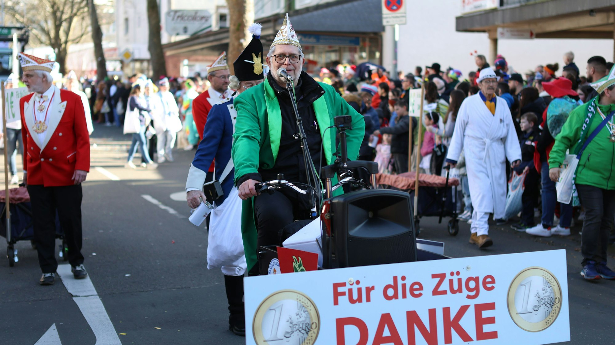 Ein Karnevalist fährt mit einer Spendenaufforderung in Opladen mit.