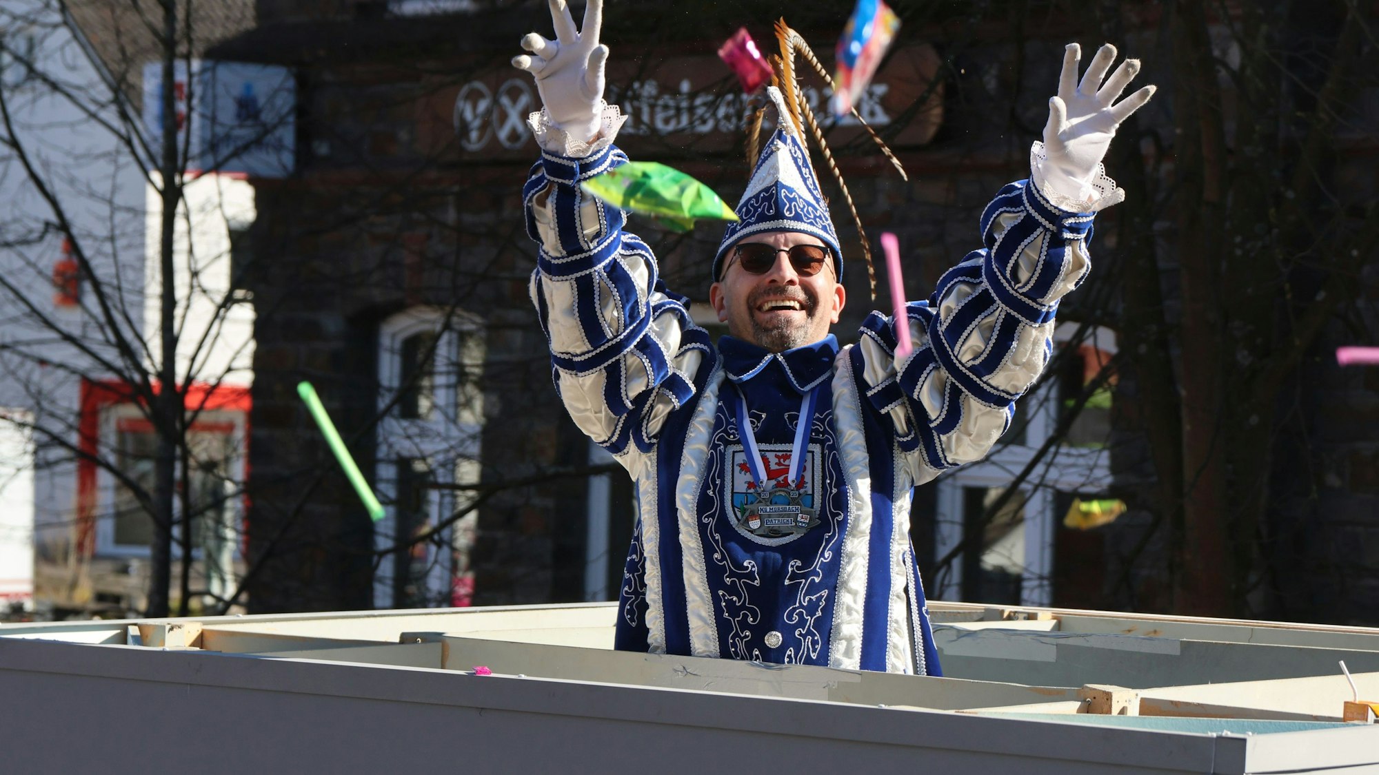 Ein Prinz wirft bei einem Karnevalszug Kamelle von einem Wagen.