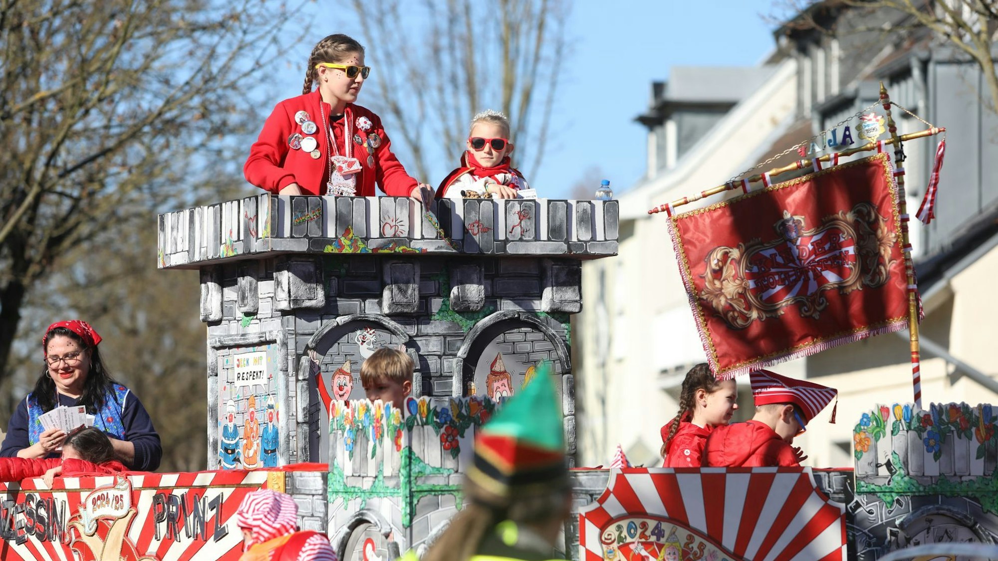 Eine Kinderprinzessin auf einem bunten Karnevalswagen.