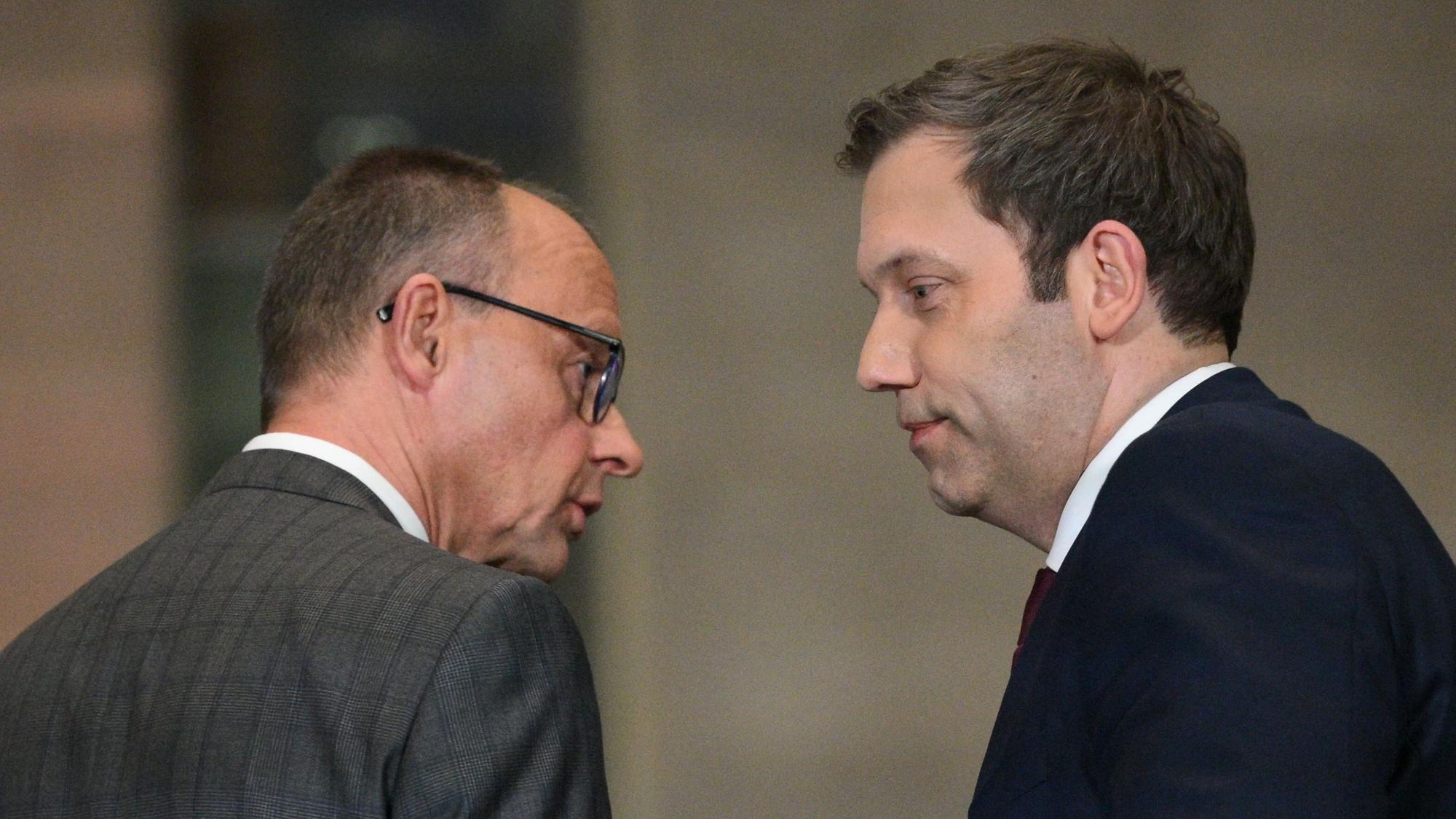 Leader of Germany's Christian Democratic Union (CDU) Friedrich Merz (L) and Germany's Social Democratic Party (SPD) Chairman Lars Klingbeil look at each other as they hold a press conference on planned major investments, in Berlin, on March 4, 2025. Germany's likely next chancellor Friedrich Merz said on March 4, 2025 his centre-right CDU/CSU and the centre-left Social Democrats (SPD) would propose hundreds of billions in extra spending on defence and the economy. (Photo by RALF HIRSCHBERGER / AFP)