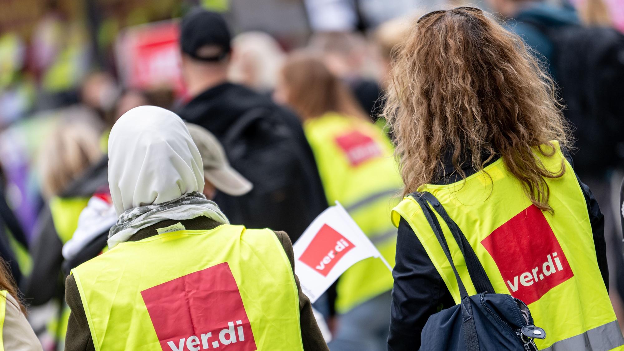 Menschen nehmen an einer Kundgebung der Gewerkschaften GEW und Verdi teil.