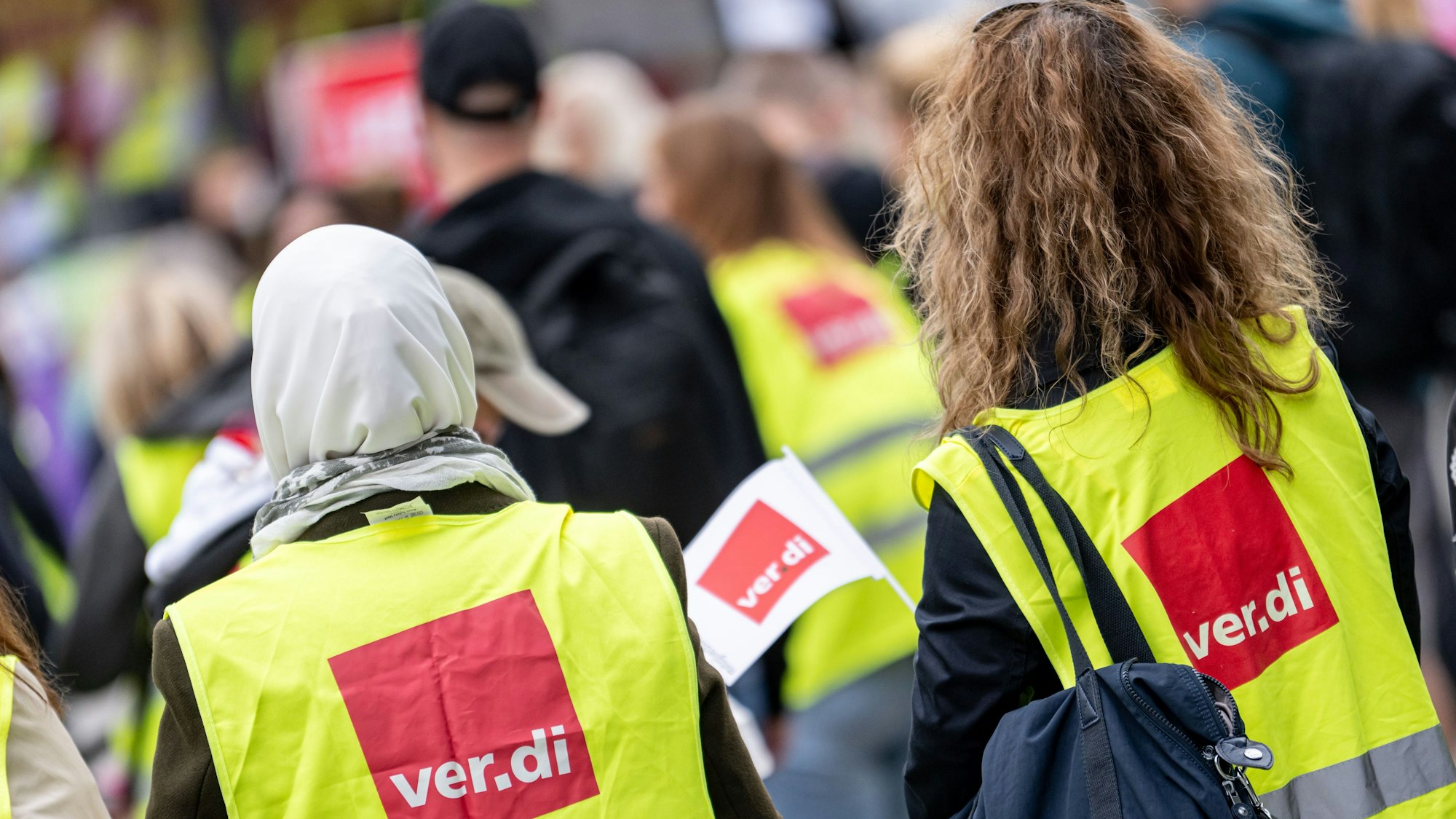 Menschen nehmen an einer Kundgebung der Gewerkschaft ver.di teil.