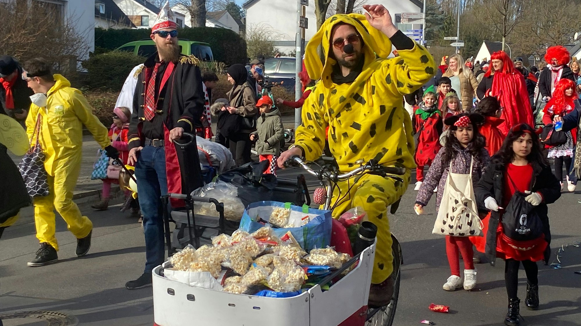 Zu sehen ist ein verkleideter Mann auf einem Lastenrad voller Popcorn.