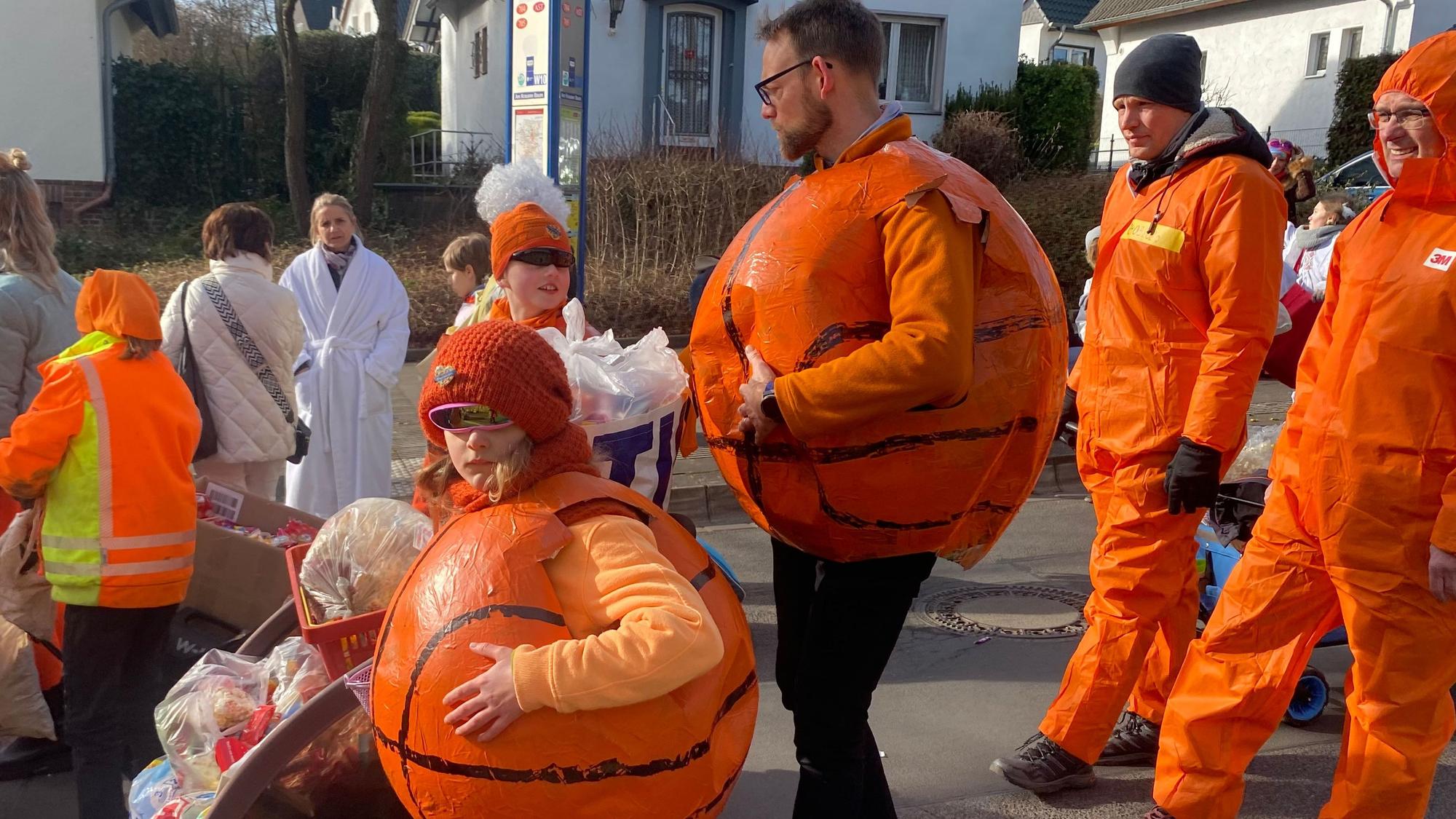 Zu sehen sind Jecke, die als Basketbälle verkleidet sind.