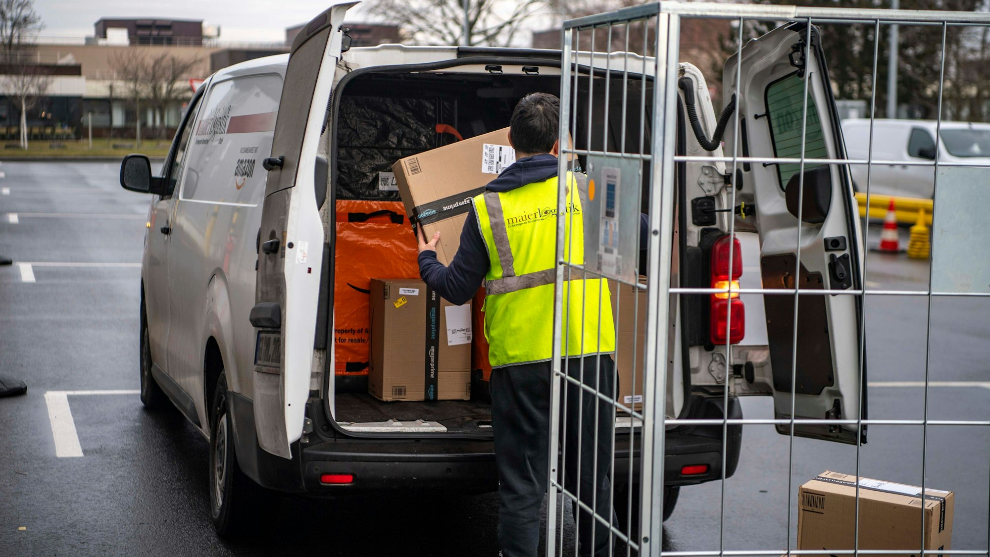 Das Bild zeigt einen Mann, der seinen Lieferwagen packt.
