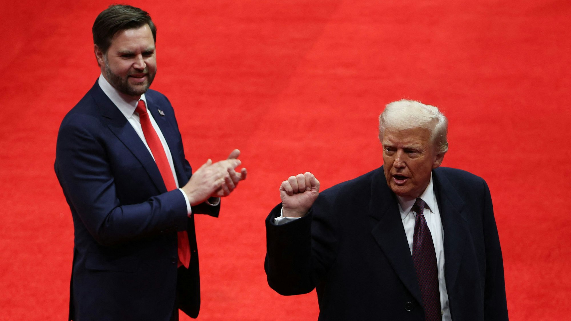 US-Vizepräsident J.D. Vance (l.) und US-Präsident Donald Trump stehen gemeinsam auf einer Bühne. (Archivbild)