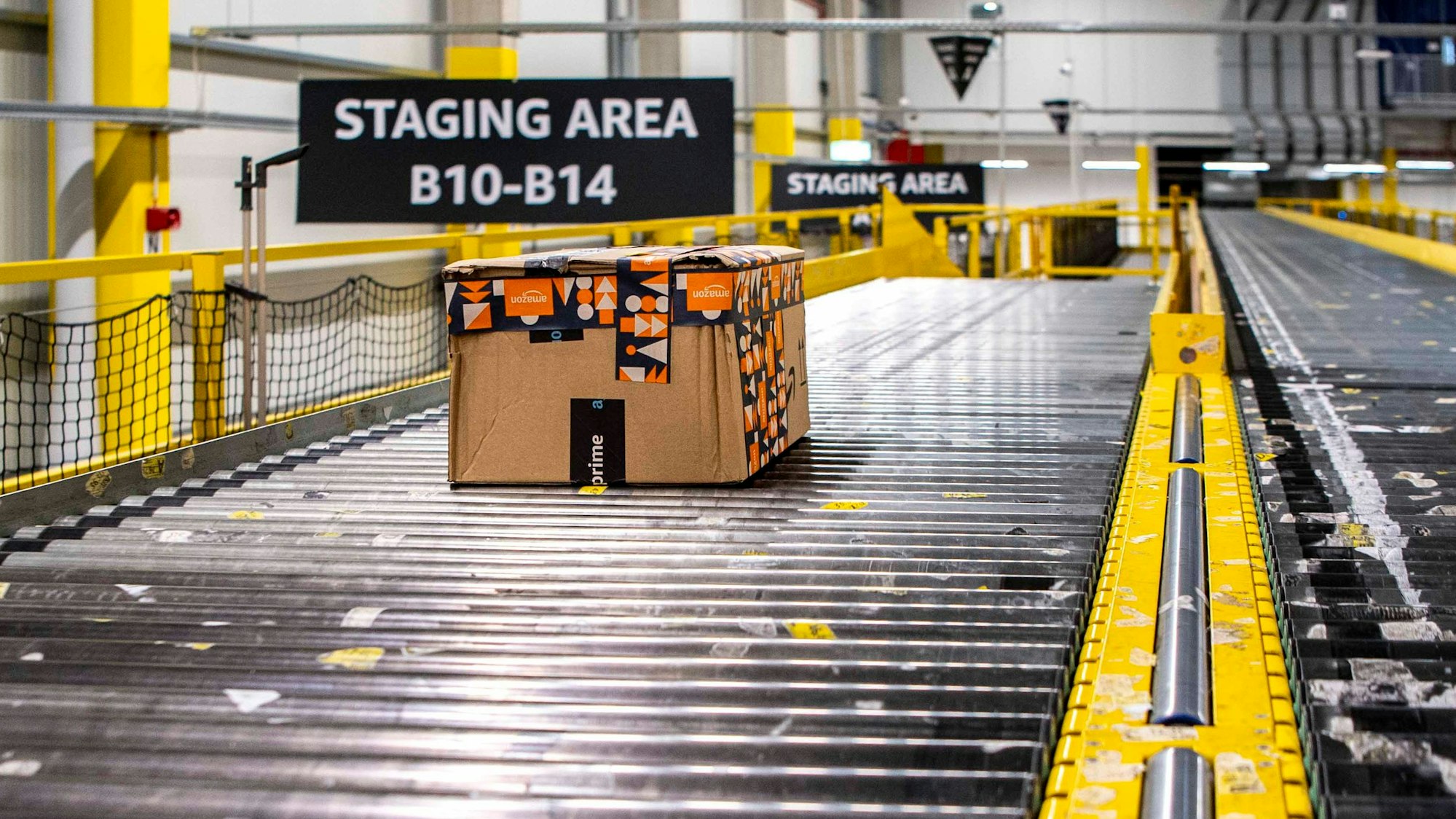 Das Bild zeigt ein Paket, das über ein Rollband durch das Verteilzentrum transportiert wird.