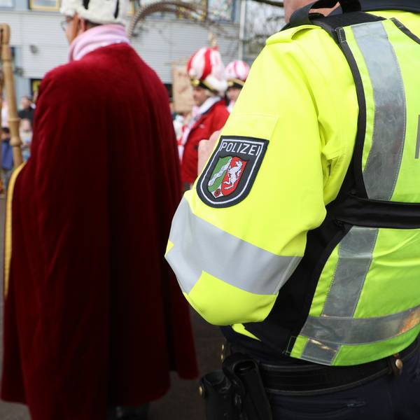 Ein Polizist steht am Rande einer Freiluft-Karnevalsveranstaltung in Bergisch Gladbach.