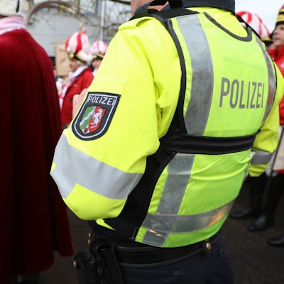 Ein Polizist steht am Rande einer Freiluft-Karnevalsveranstaltung in Bergisch Gladbach.