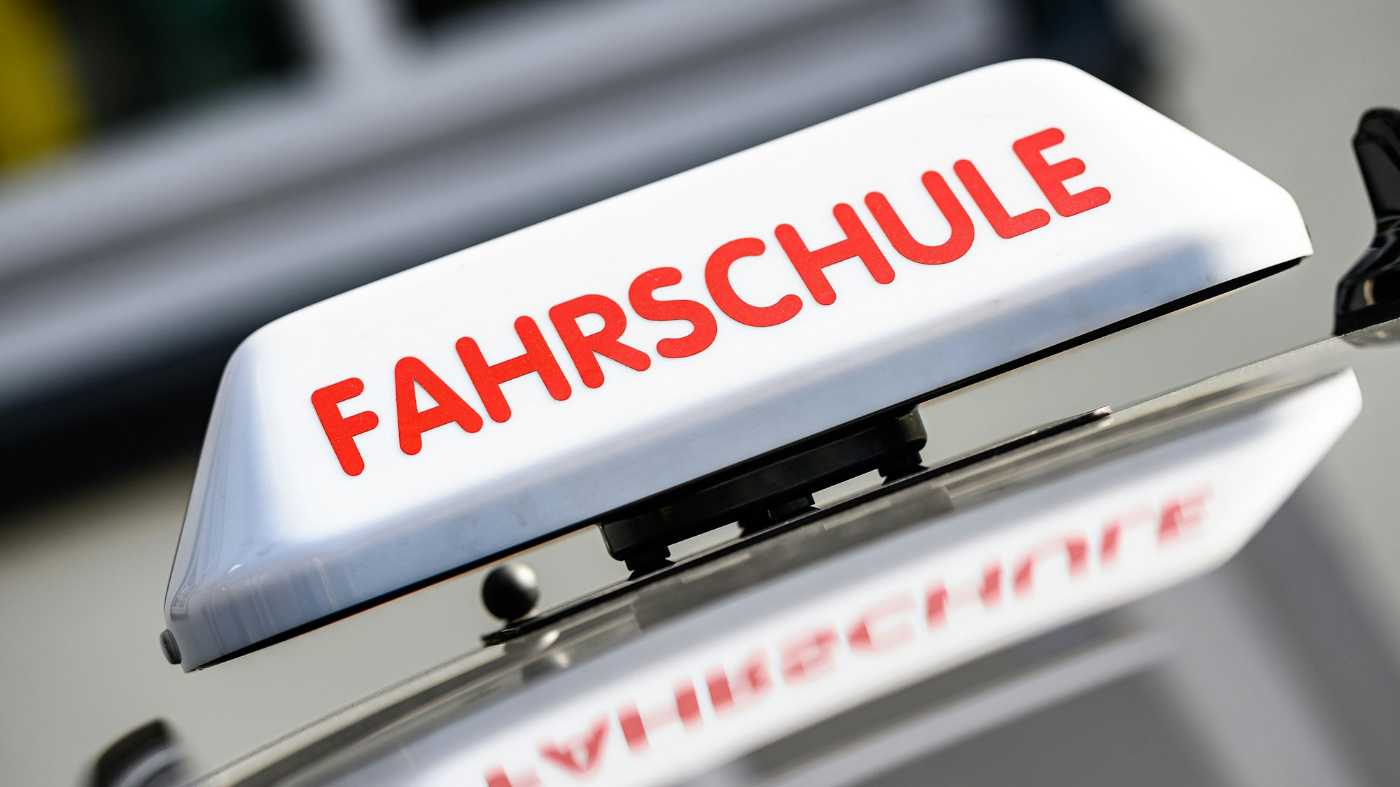 Ein Dachzeichen mit der Aufschrift „Fahrschule “ist an einem Fahrschulauto angebracht. (Symbolbild)