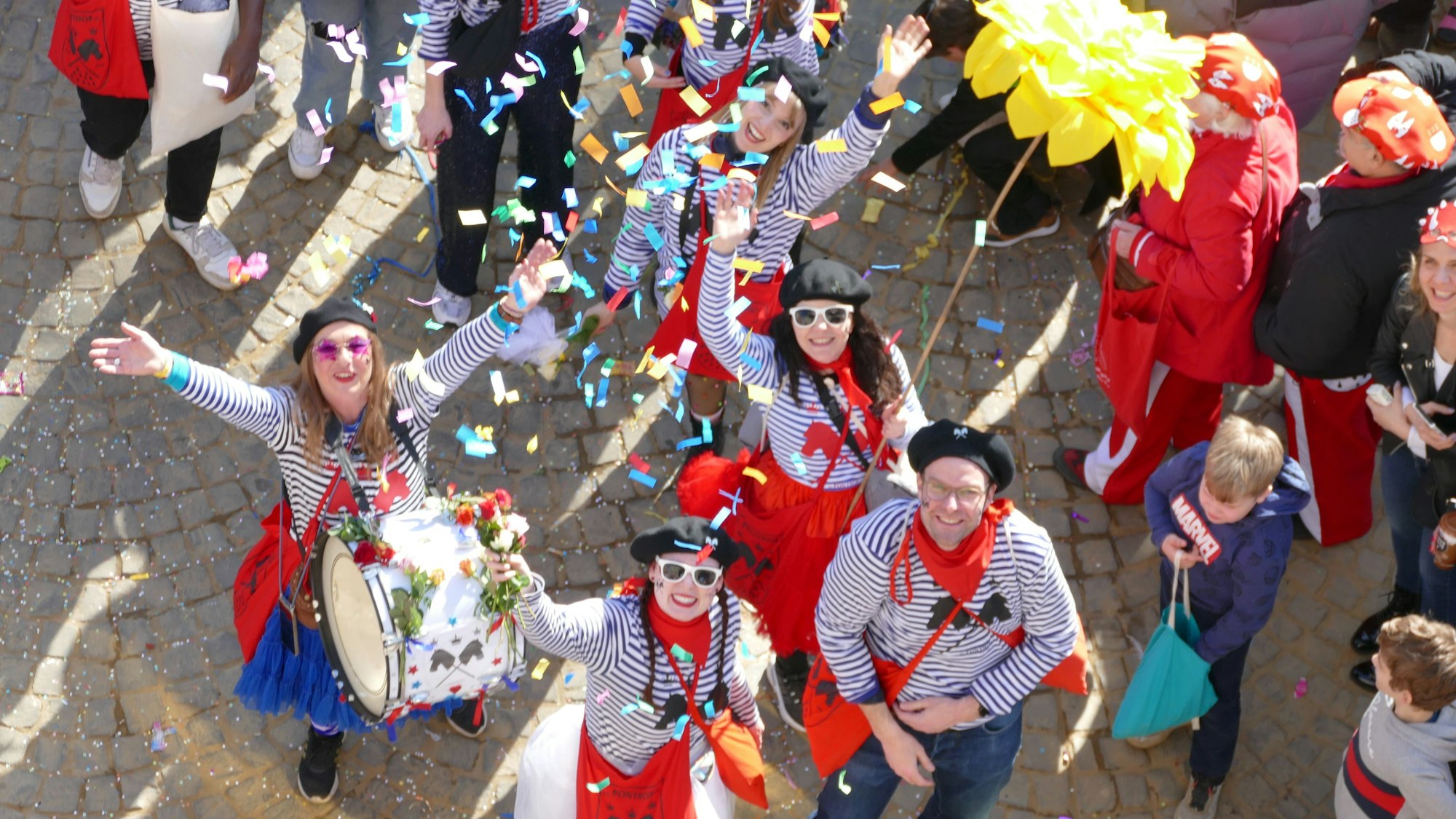 Jecke schauen nach oben und werfen Konfetti.