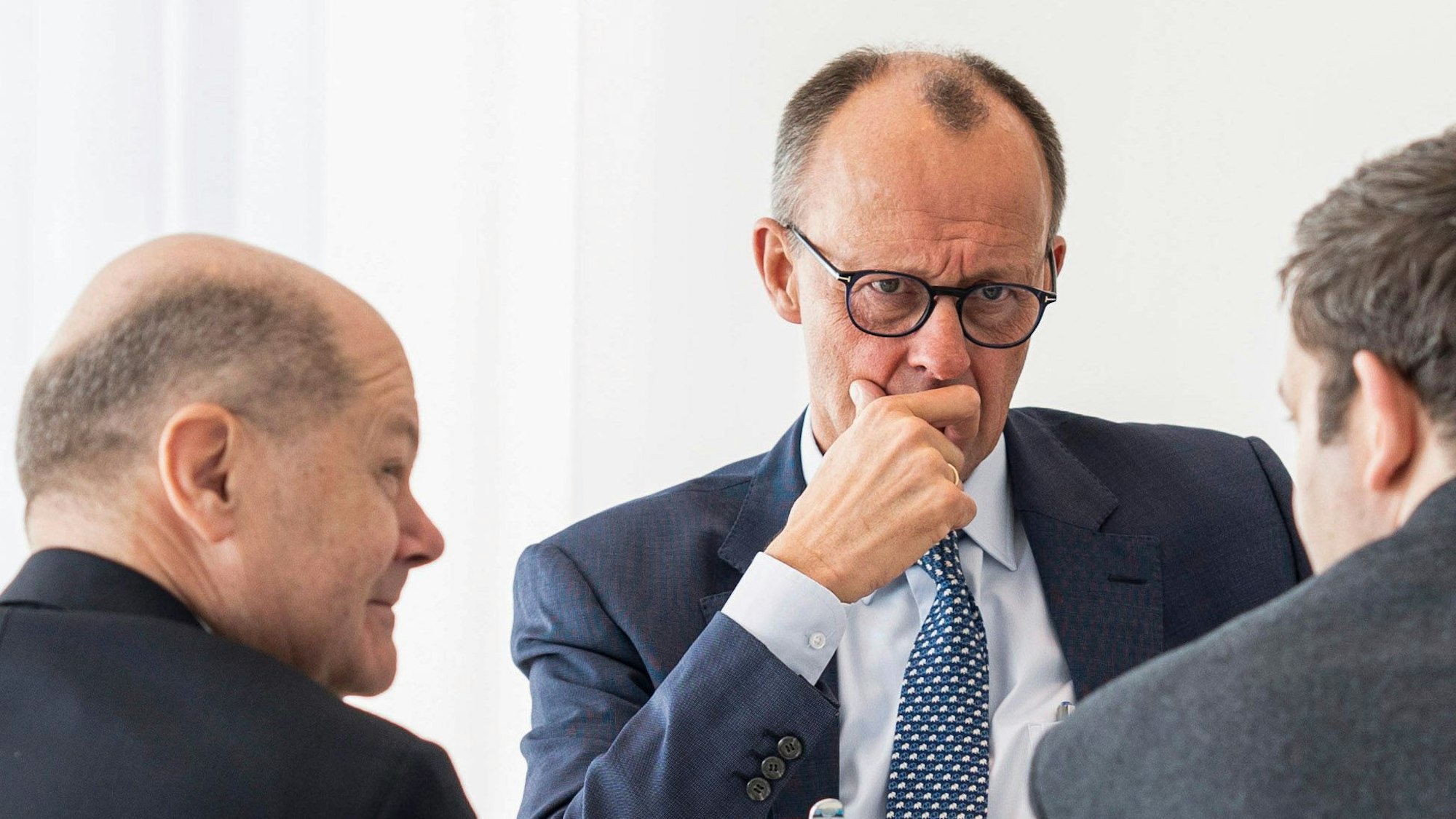 Der amtierende Bundeskanzler Olaf Scholz (SPD, l-r) unterhält sich mit dem künftigen Kanzler Friedrich Merz (CDU) und Lars Klingbeil, (SPD).