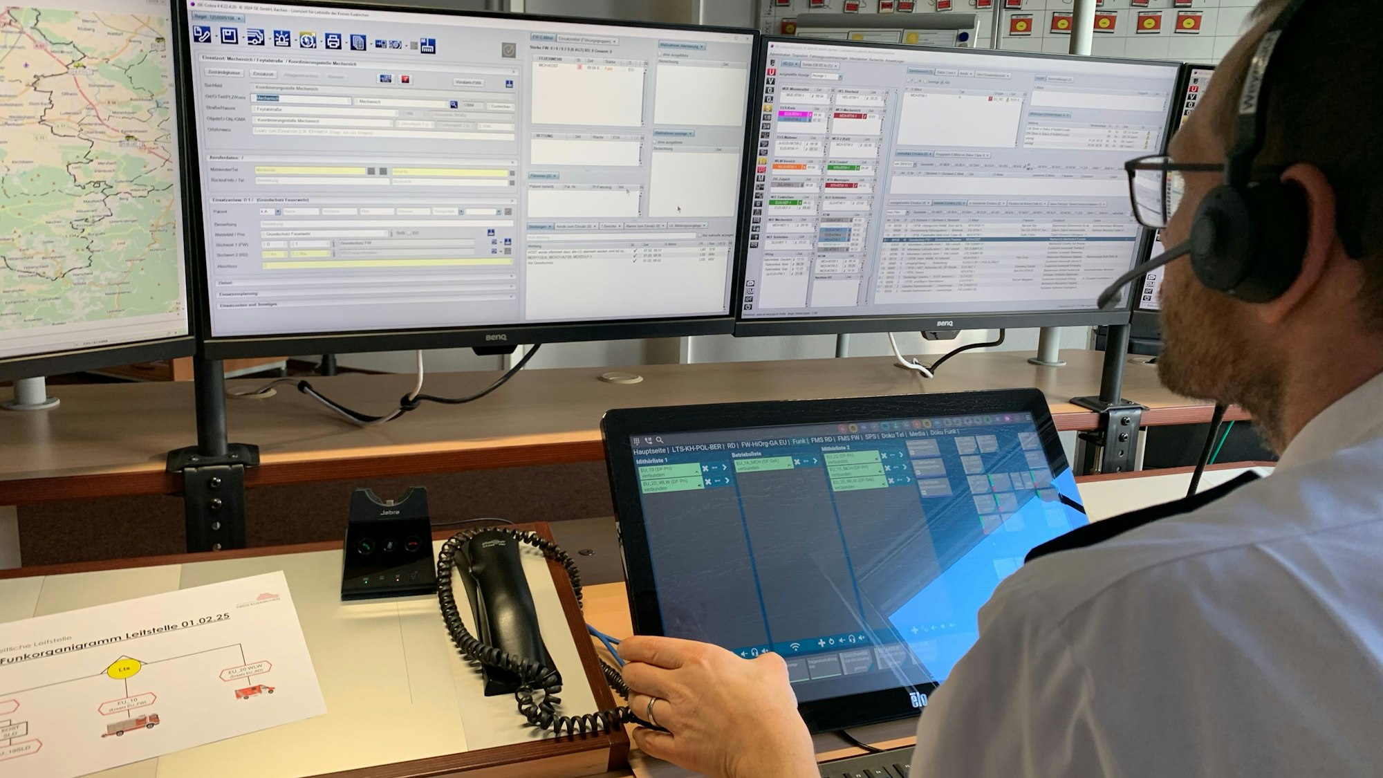 Das Bild zeigt einen Disponenten in der Leitstelle. Er schaut auf zwei Bildschirme.