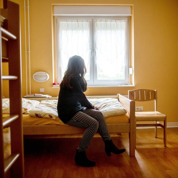 Eine Frau sitzt im Frauenhaus auf einem Bett. Das Gleichstellungsministerium in NRW möchte Frauenhäuser stärker fördern. +++ dpa-Bildfunk +++
