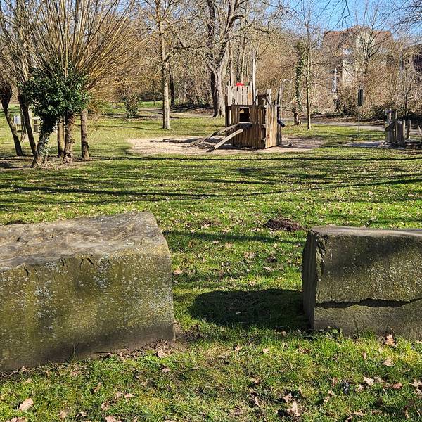 Zu sehen ist ein Park mit Findlingen und einem Spielplatz.