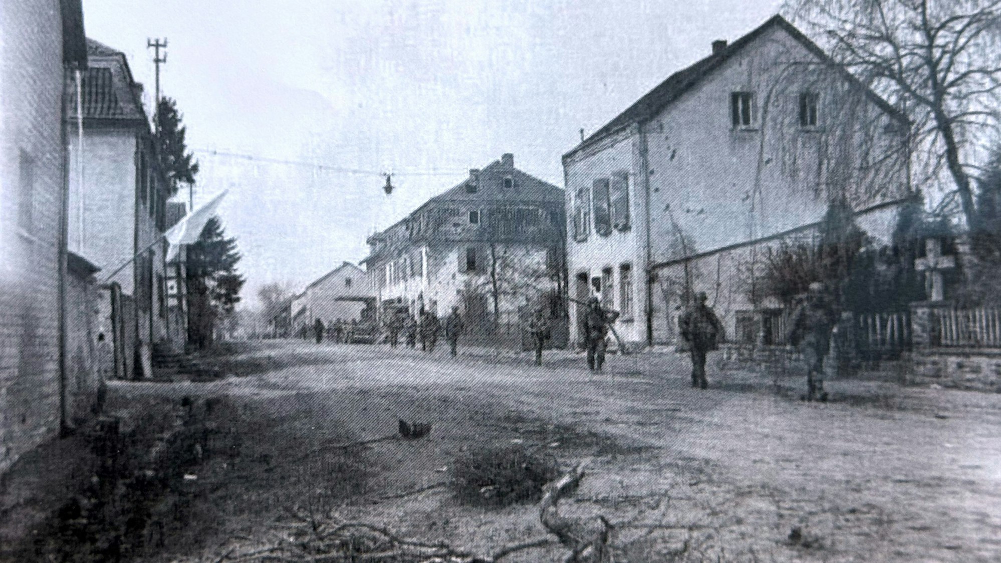 US-Soldaten gehen über eine Straße, die von Häusern gesäumt ist.