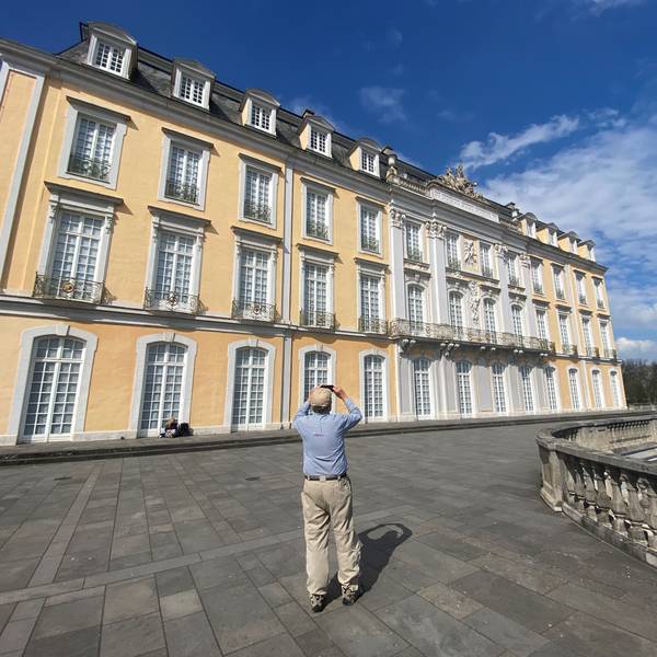 Zu sehen ist ein Mann, der das Schloss Augustusburg fotografiert.