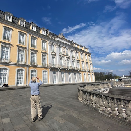 Zu sehen ist ein Mann, der das Schloss Augustusburg fotografiert.