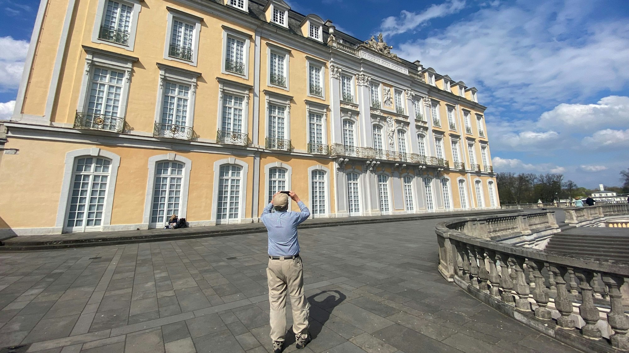 Zu sehen ist ein Mann, der das Schloss Augustusburg fotografiert.