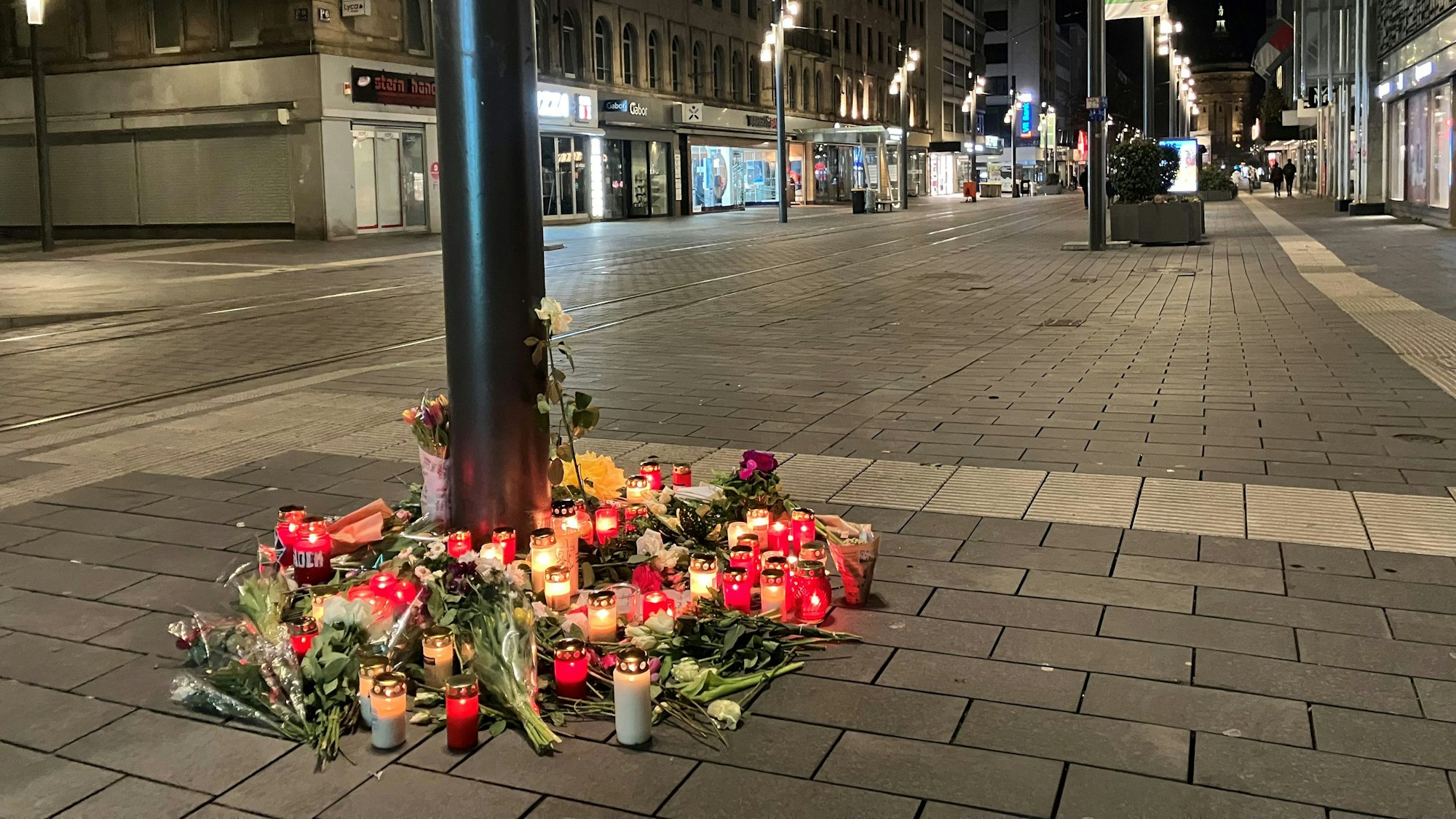 Das Bild zeigt Kerzen und Blumen, die in der Nähe des Paradeplatzes an einer Straßenbahn-Haltestelle in Mannheim zum Gedenken an die Opfer der Amokfahrt vom 03. März 2025 hingelegt wurden.