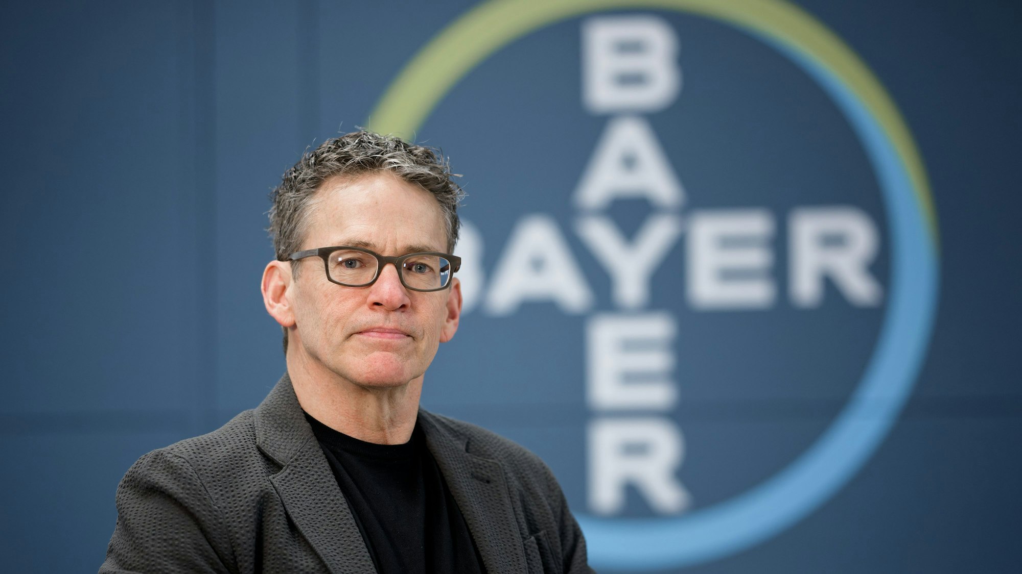 ARCHIV - 10.12.2024, Nordrhein-Westfalen, Leverkusen: Bill Anderson, Vorstandsvorsitzender der Bayer AG, sitzt bei einem Fototermin in der Zentrale des Unternehmens. (zu dpa: «Chemiekonzern Bayer erneut vor schwierigem Jahr») Foto: Henning Kaiser/dpa +++ dpa-Bildfunk +++