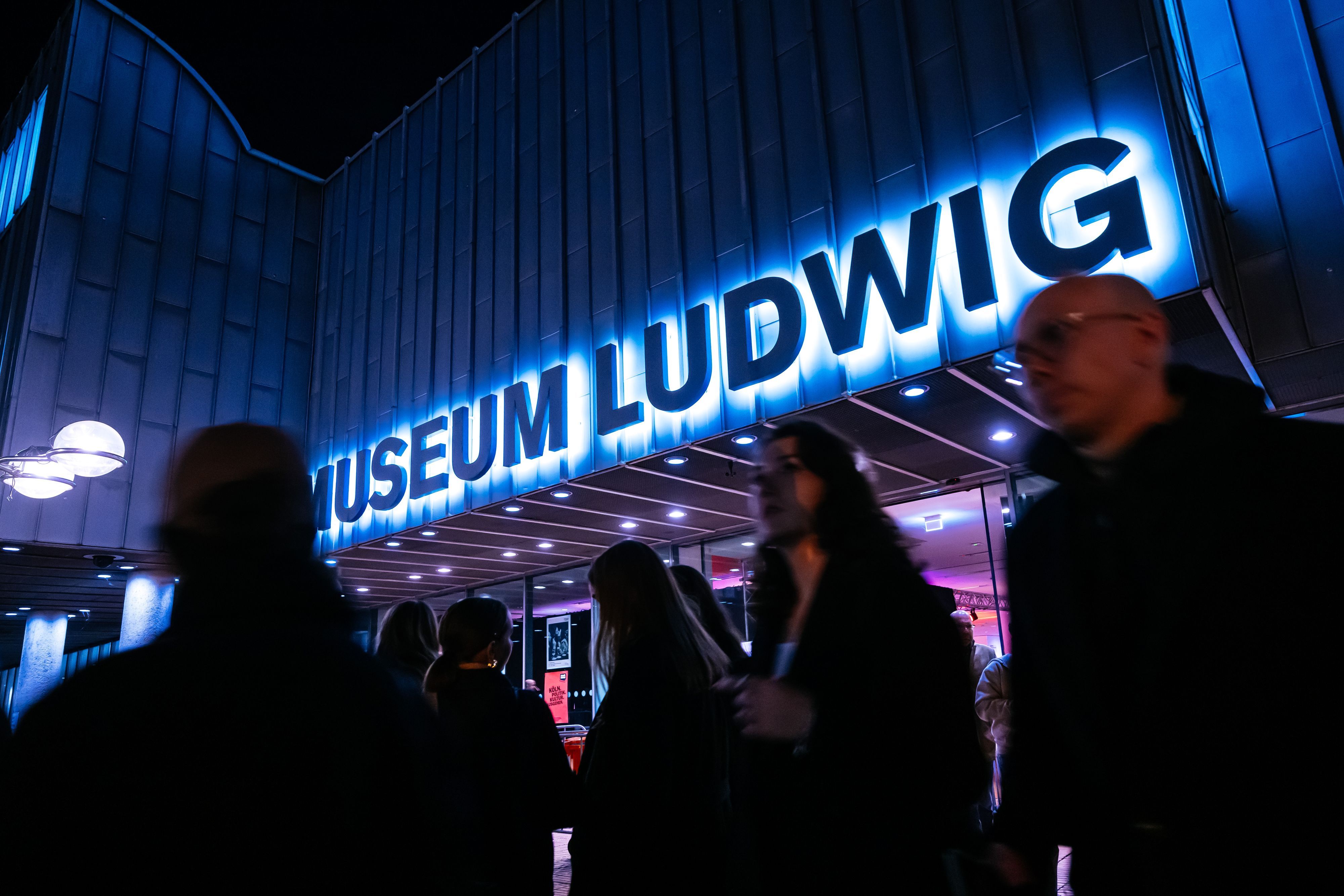 Eingang des Museum Ludwig leuchtet Neon in der Nacht.