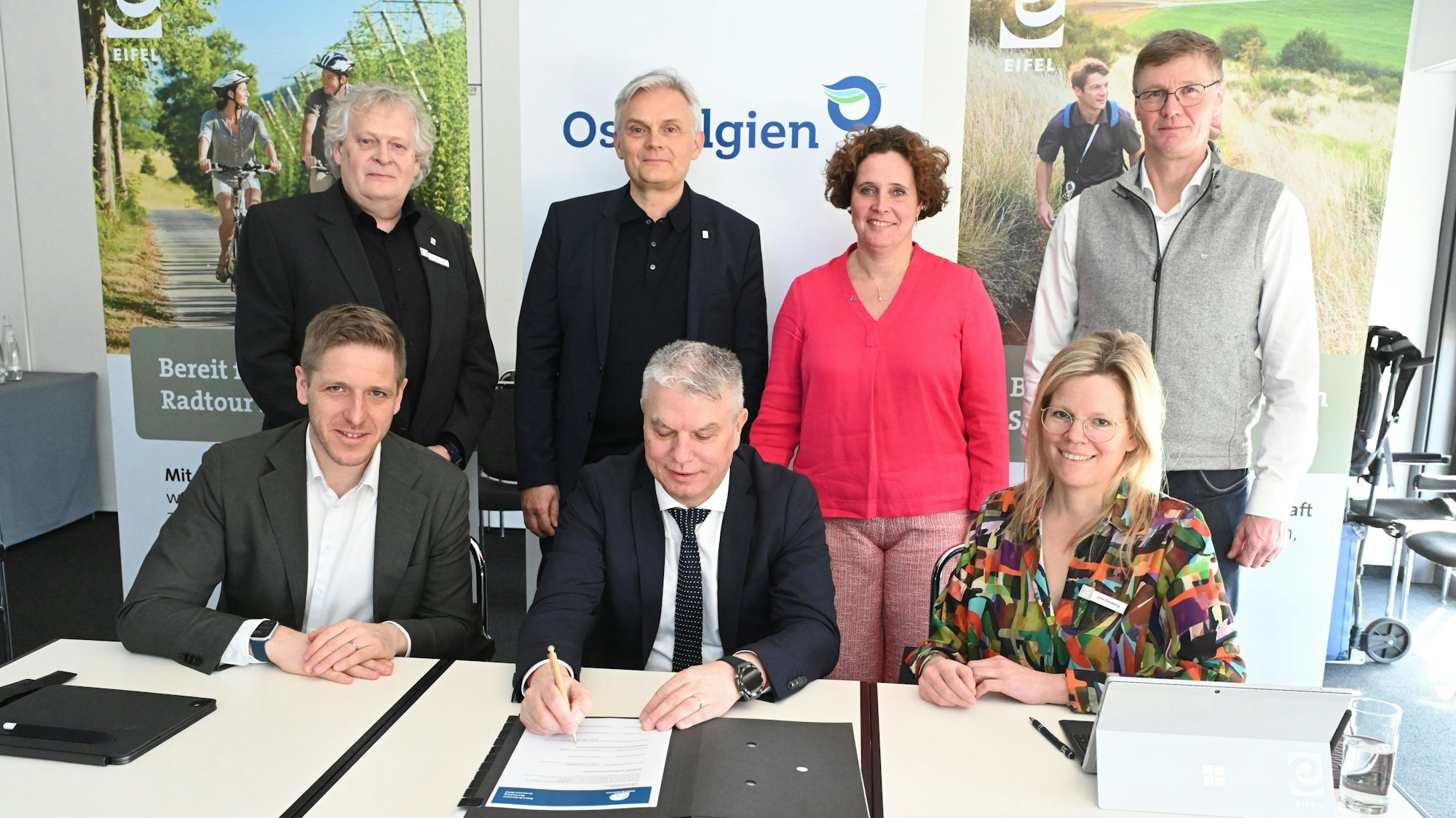 Hibbo Tammena, Geschäftsführender Vorstand EWIV, Wolfgang Reh, neuer Geschäftsführer EWIV EAM , Sandra De Taeye, Geschäftsführender Vorstand, Dany Heck, Tourismusagentur Ostbelgien (oben von links nach rechts. Landrat Markus Ramers, Aufsichtsratsvorsitzender Eifel Tourismus GmbH, Minister Gregor Freches, Deutschsprachige Gemeinschaft Belgiens, Landrätin Julia Gieseking, Stellv. Aufsichtsratsvorsitzende Eifel Tourismus GmbH unterschreiben das neue Beschlussprotokoll.