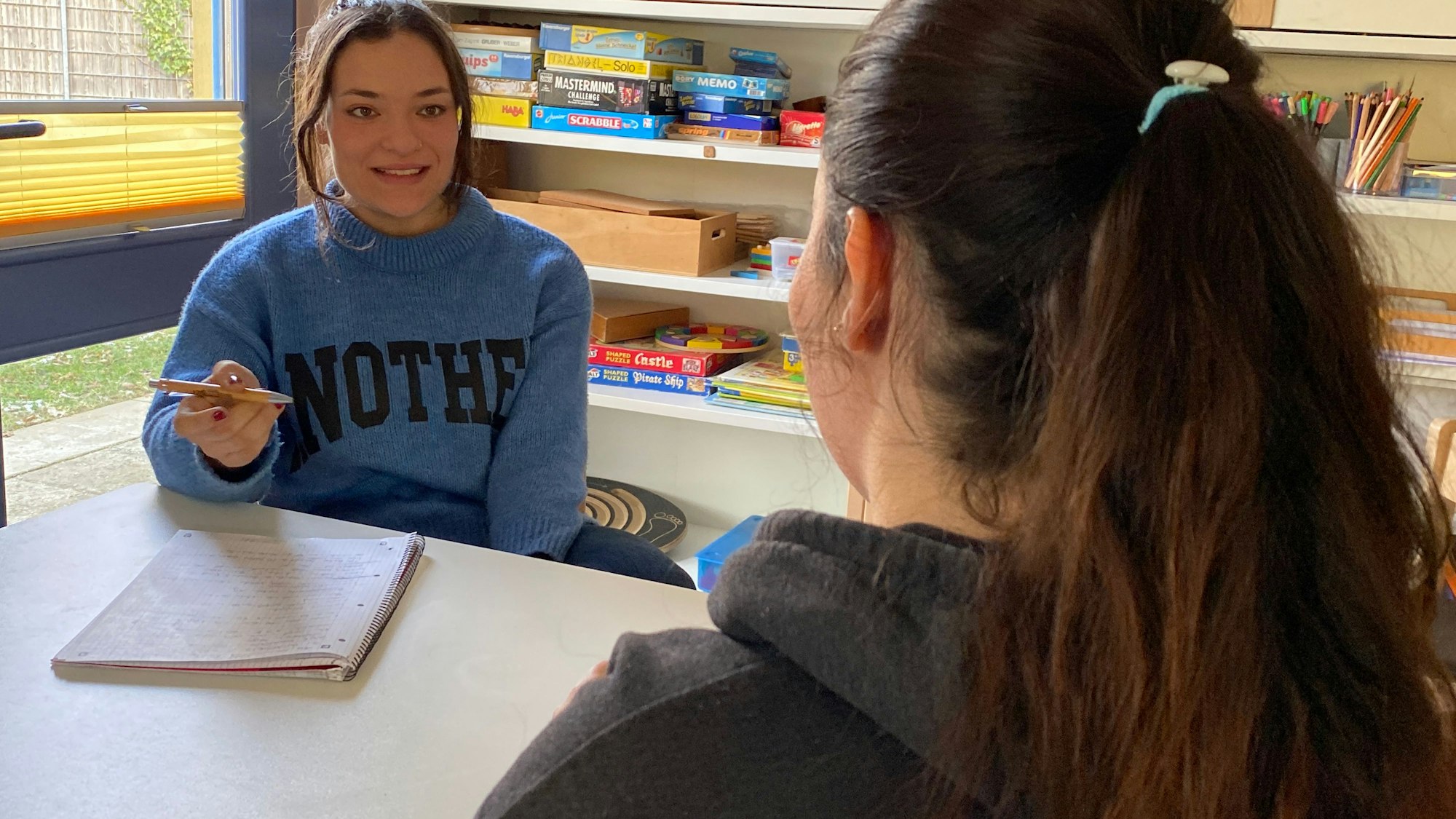 Alesha Gasior sitzt bei einem Gespräch einer Bewohnerin gegenüber.