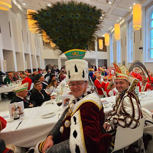 Bauer Michael, Prinz Christian I. und Jungfrau Steffi sitzen an einem Tisch beim Prinzenessen im Kardinal-Schulte-Haus.