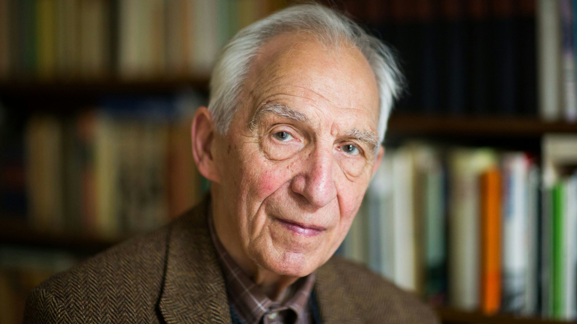 Porträt des Schriftstellers Dieter Wellershoff vor einer Bücherwand