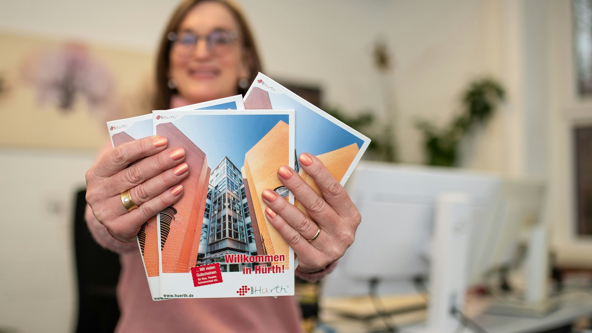 Auf dem Bild sind zwei Hände zu sehen, sie halten eine Broschüre.