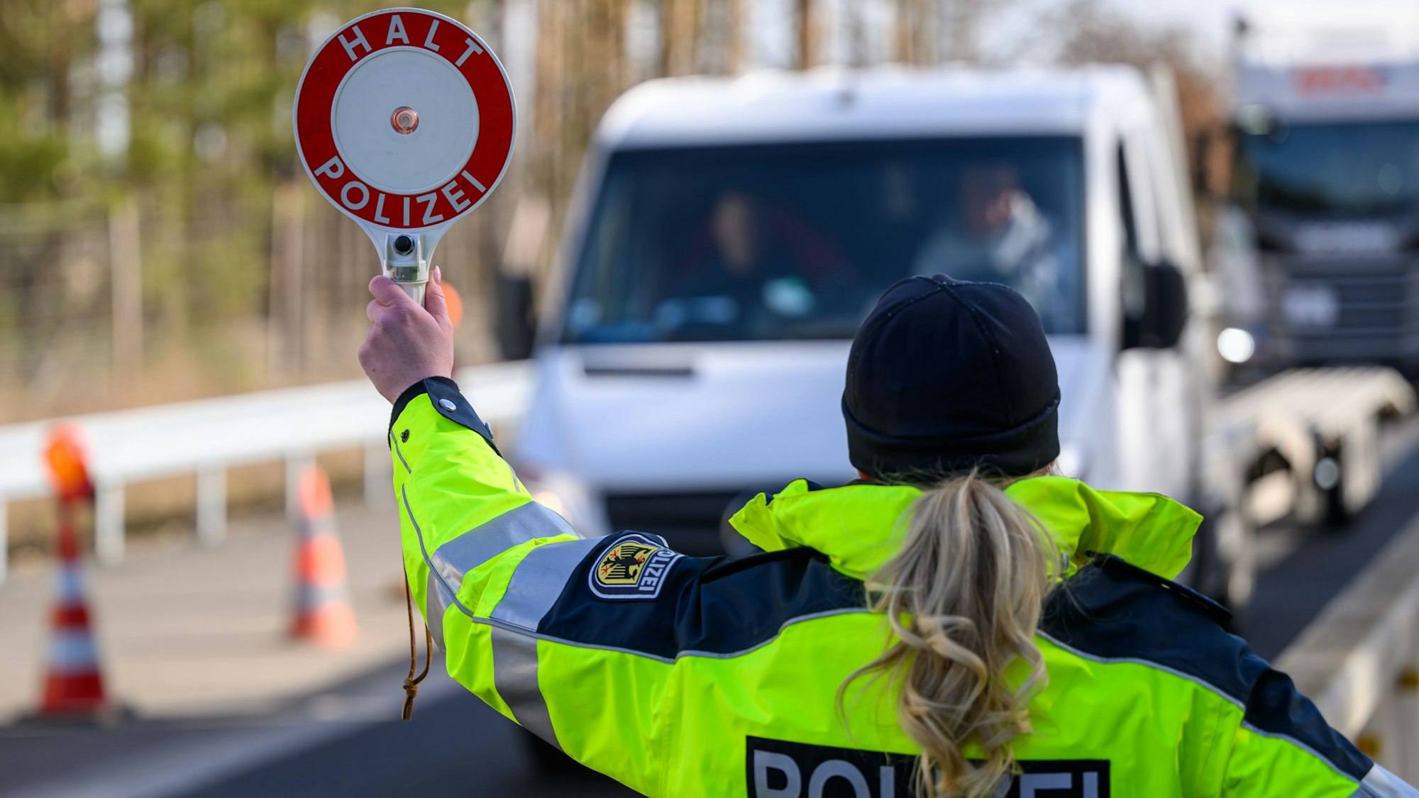 04.03.2025, Brandenburg, Forst: Eine Beamtin der Bundespolizei stoppt bei der Eireisekontrolle am deutsch-polnischen Autobahngrenzübergang A15 bei Forst ein Fahrzeug. Migration war im Wahlkampf ein Hauptstreitthema zwischen Union und SPD. Jetzt kommt es in den Sondierungsgesprächen auf den Tisch. (zu dpa "Klingbeil zieht rote Linie beim Thema Migration") Foto: Patrick Pleul/dpa +++ dpa-Bildfunk +++