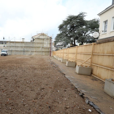 Eine große, mit Sand bedeckte Fläche, links im Hintergrund das ehemalige Gebäude der Post in Bad Honnef.