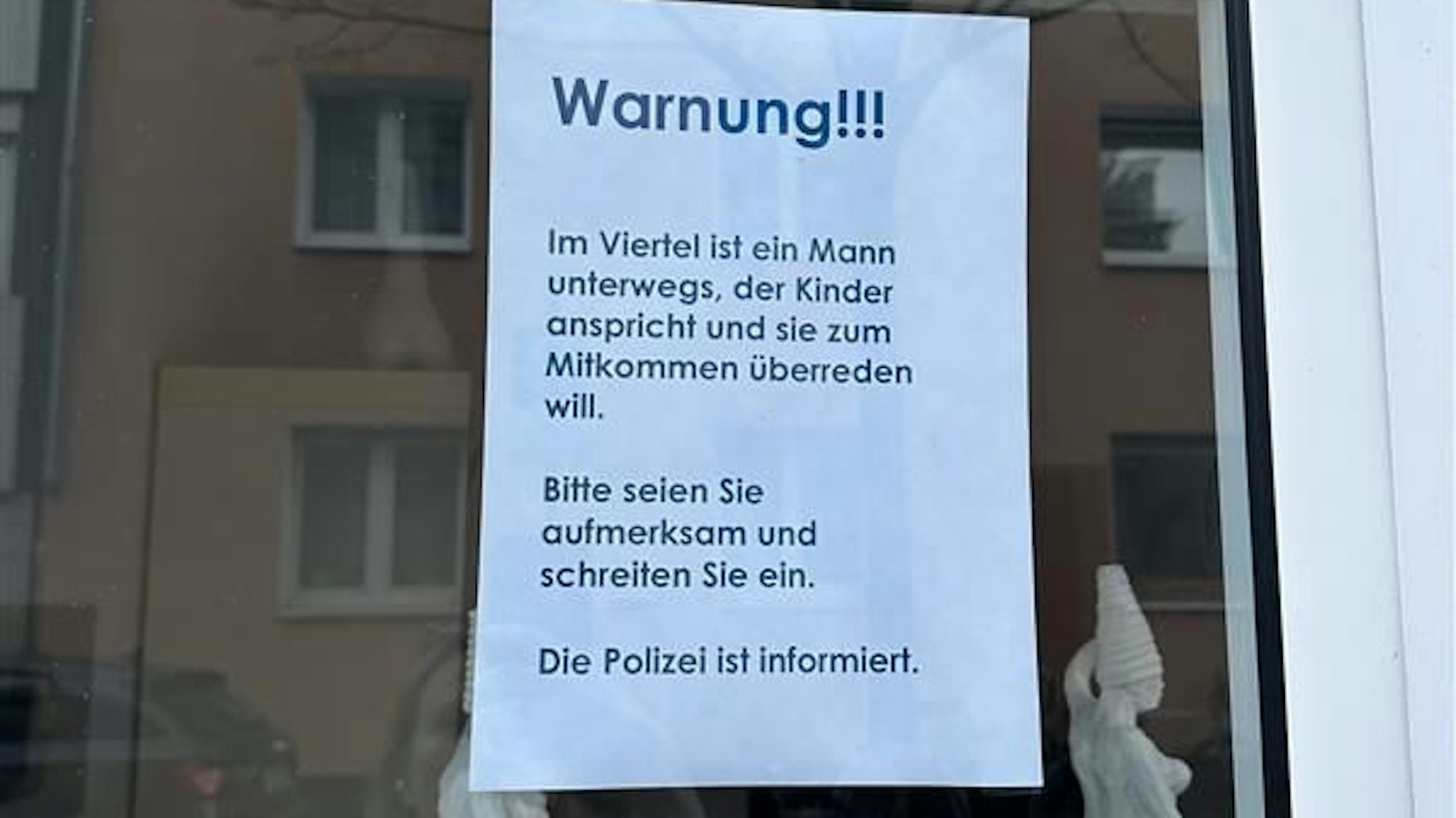 Ein Zettel mit der Überschrift „Warnung!!!“ Darunter der Text: „Im Viertel ist ein Mann unterwegs, der Kinder anspricht und sie zum Mitkommen überreden will. Bitte seien Sie aufmerksam und schreiten Sie ein. Die Polizei ist informiert.“