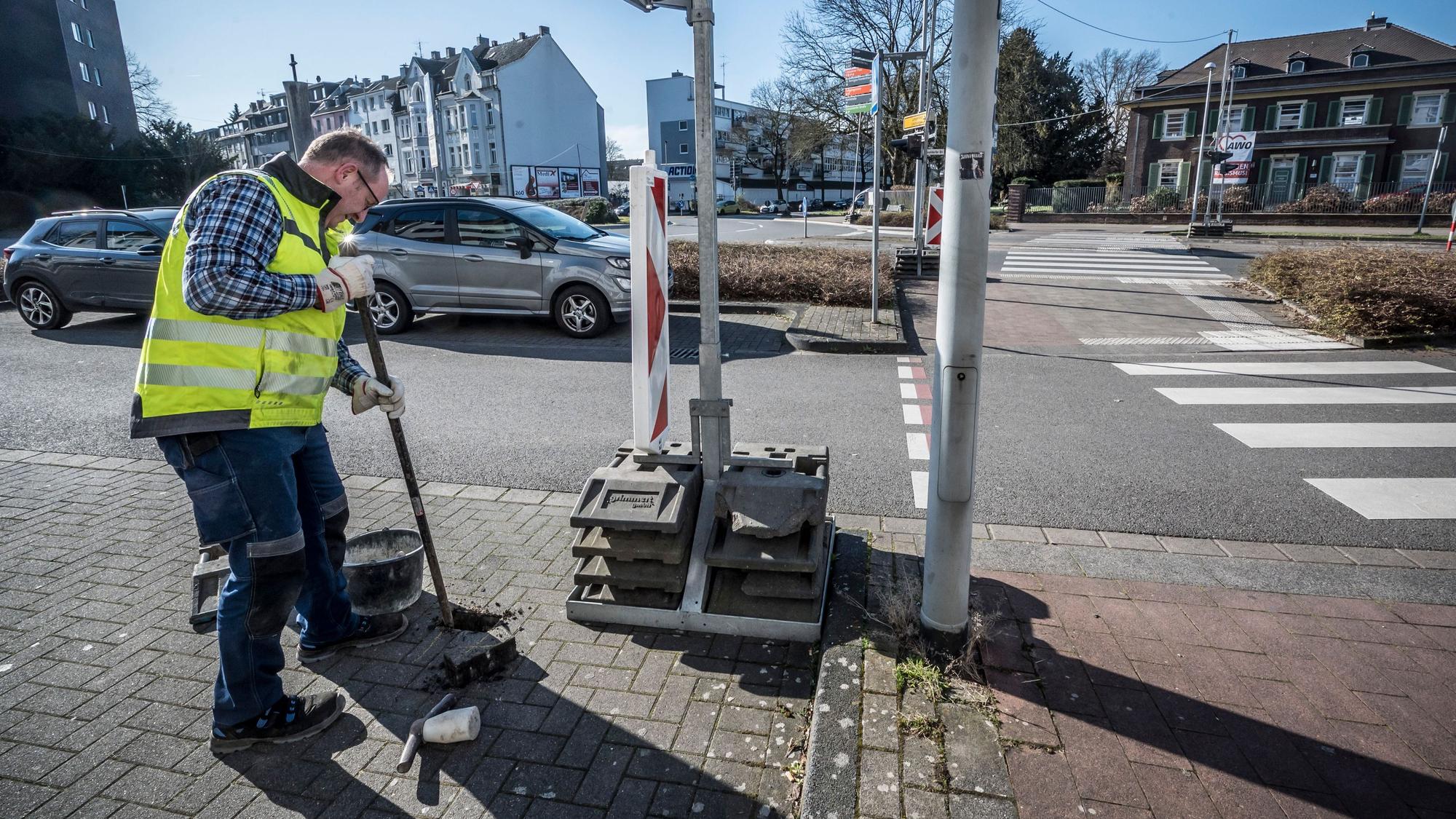 Kreisverkehr Berliner Platz: Ein Mitarbeiter setzt Poller. Weil niemand mehr dort parken kann, soll die Sicht besser werden.