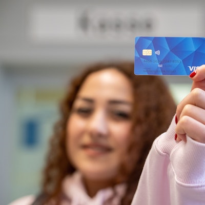 Meri aus Armenien zeigt eine Musterkarte einer sogenannten Bezahlkarte für Geflüchtete in Rheinland-Pfalz.