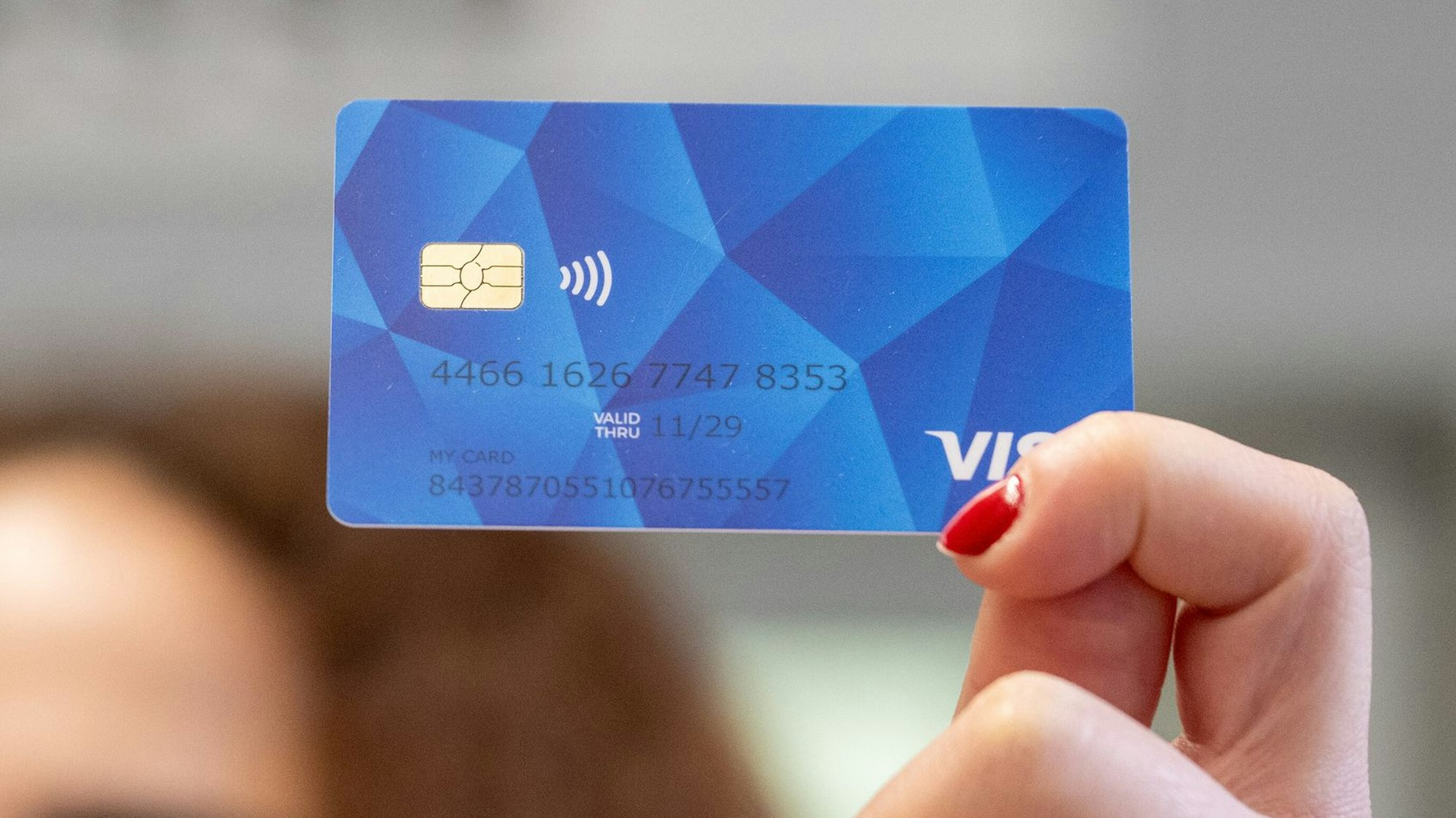 Meri aus Armenien zeigt eine Musterkarte einer sogenannten Bezahlkarte für Geflüchtete in Rheinland-Pfalz.