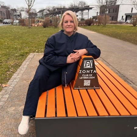 Cornelia Richrath sitzt auf einer orangenen Bank-