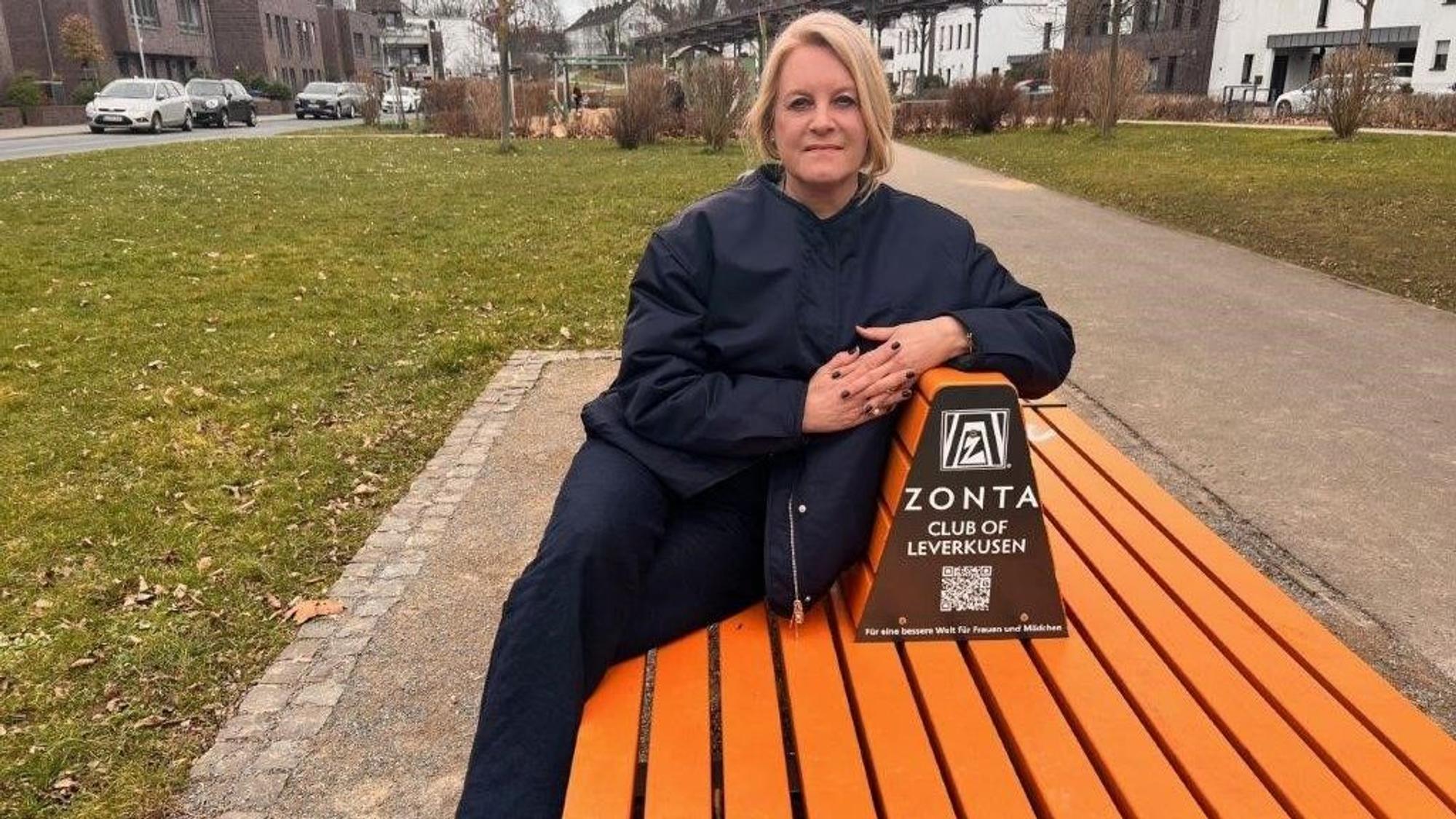 Cornelia Richrath sitzt auf einer orangenen Bank-