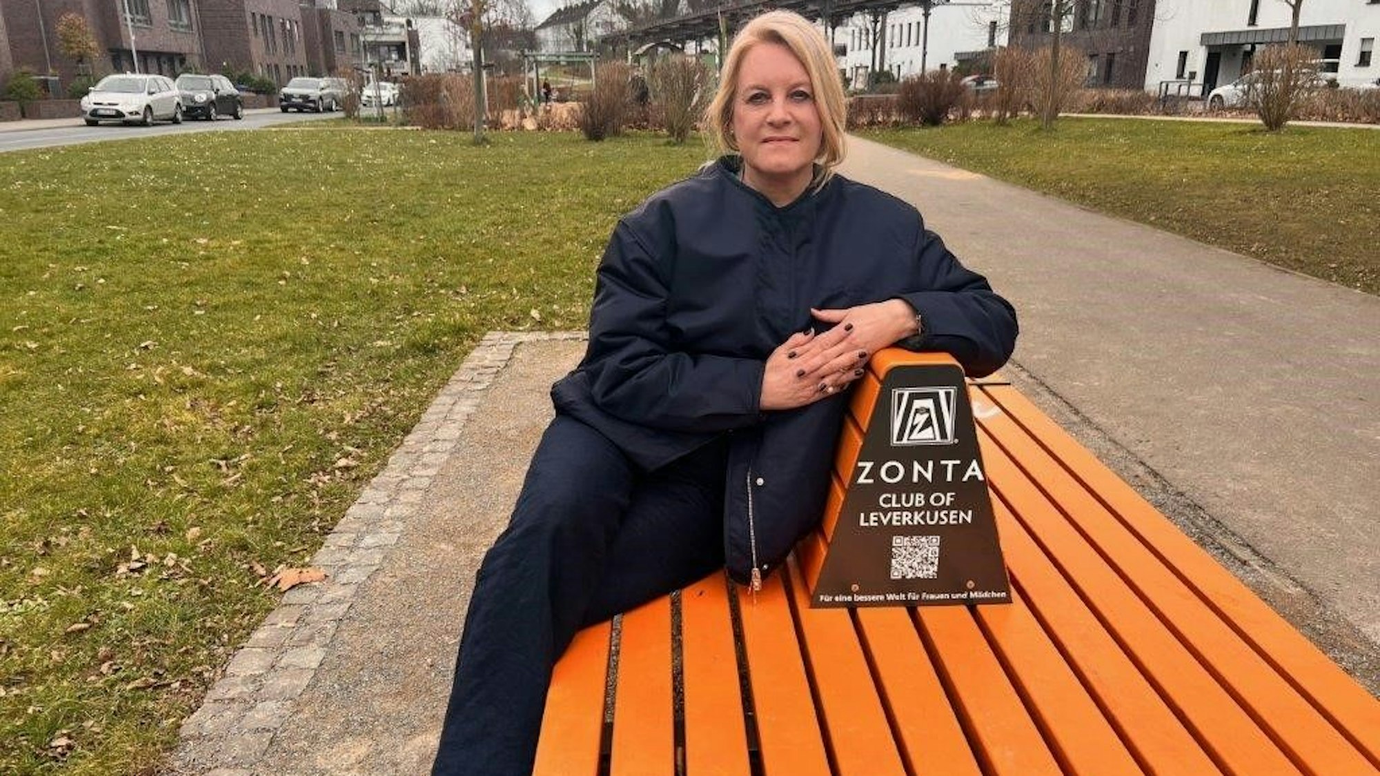 Cornelia Richrath sitzt auf einer orangenen Bank-