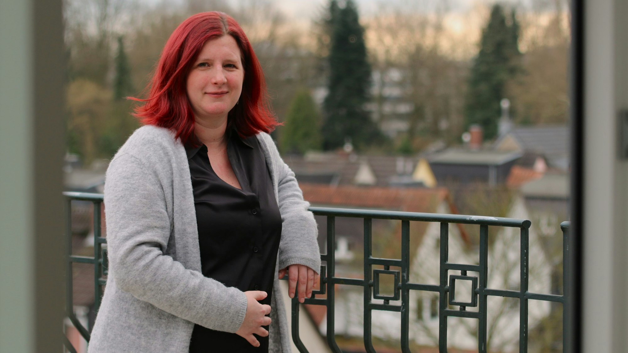 Rosa Welsch steht auf einer Dachterasse, eine Hand liegt auf ihrem schwangeren Bauch.