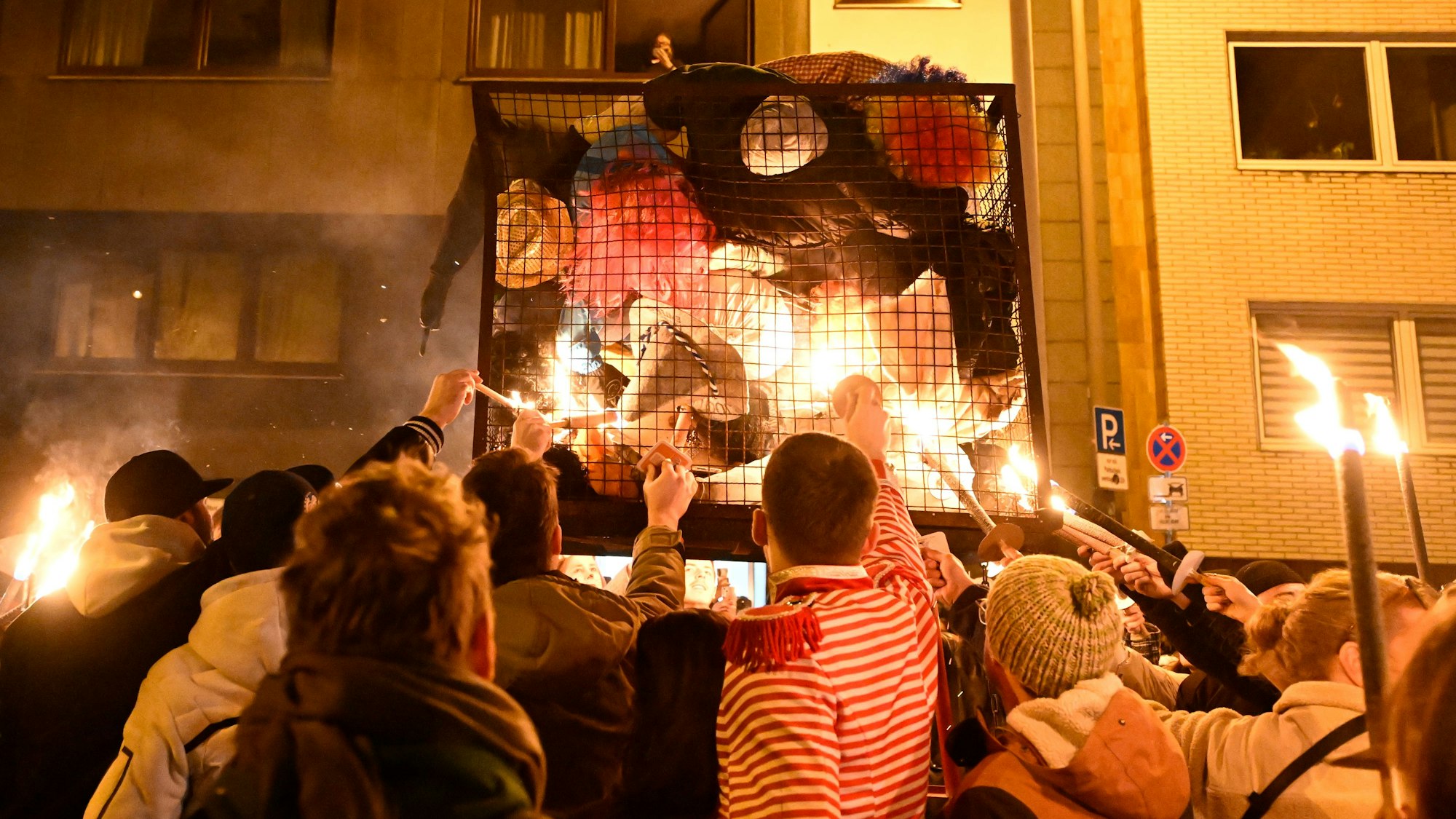 Karnevalisten zündeln ihre Nubbel in einem Gefängniskäfig an.
