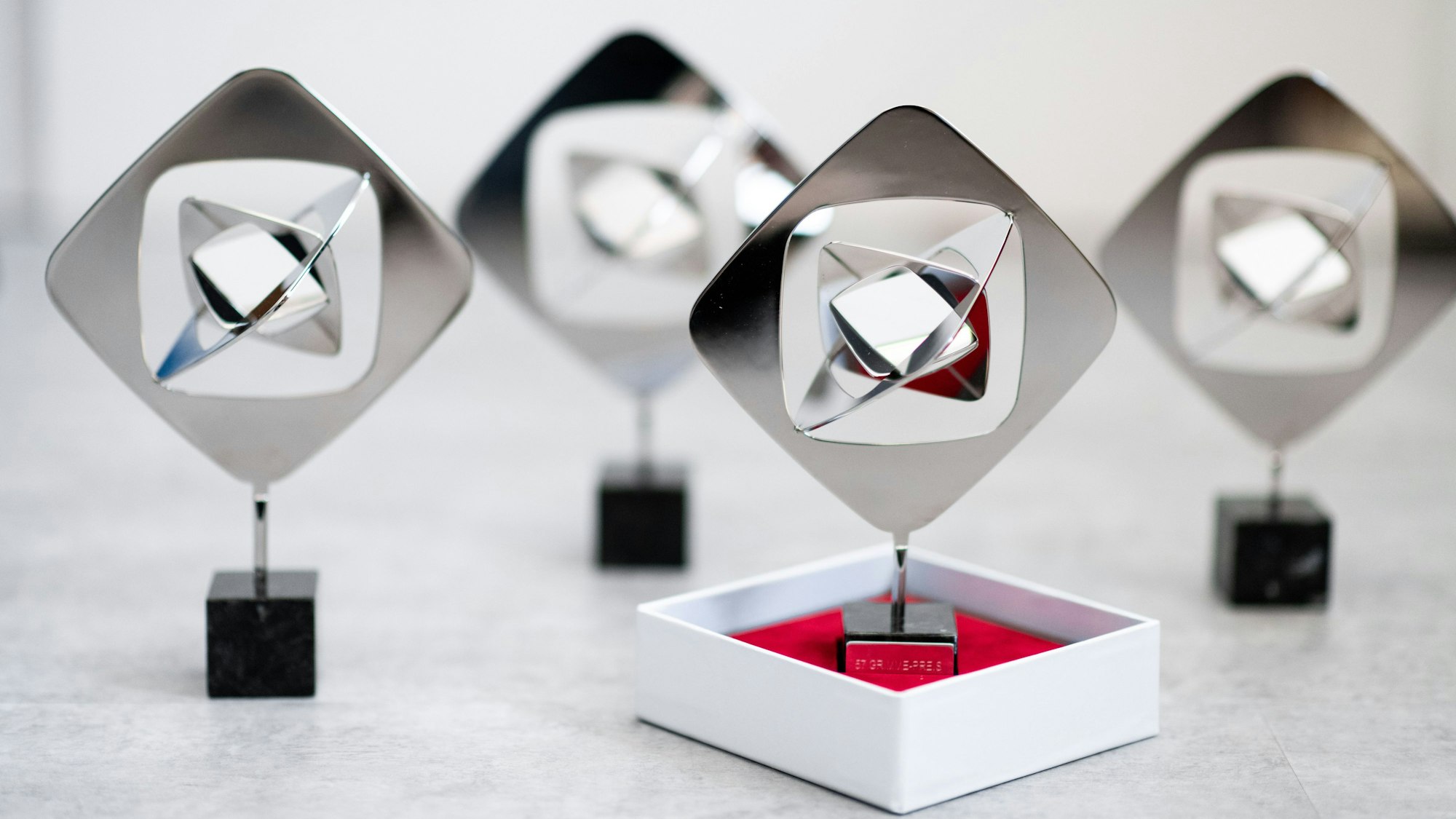 Mehrere Trophäen zum Grimme-Preis stehen in einer Juwelierwerkstatt.