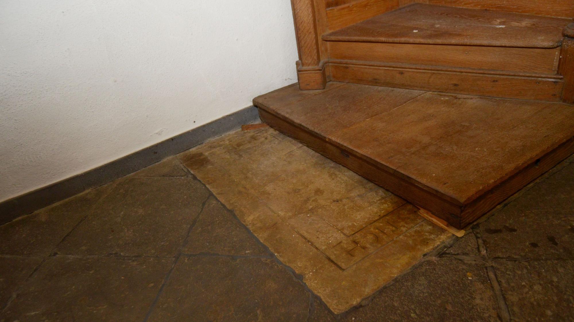 Der Boden des aus Holz gefertigten Beichtstuhls liegt auf der steinernen Platte.