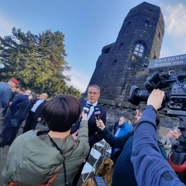 Journalisten interviewen vor den Türmen der Remagener Brücke den Ministerpräsidenten von Rheinland-Pfalz.