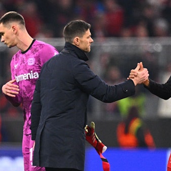 Leverkusens Trainer Xabi Alonso (M) bedankt sich nach dem Spiel bei Torwart Matej Kovar (l) und Jonathan Tah.