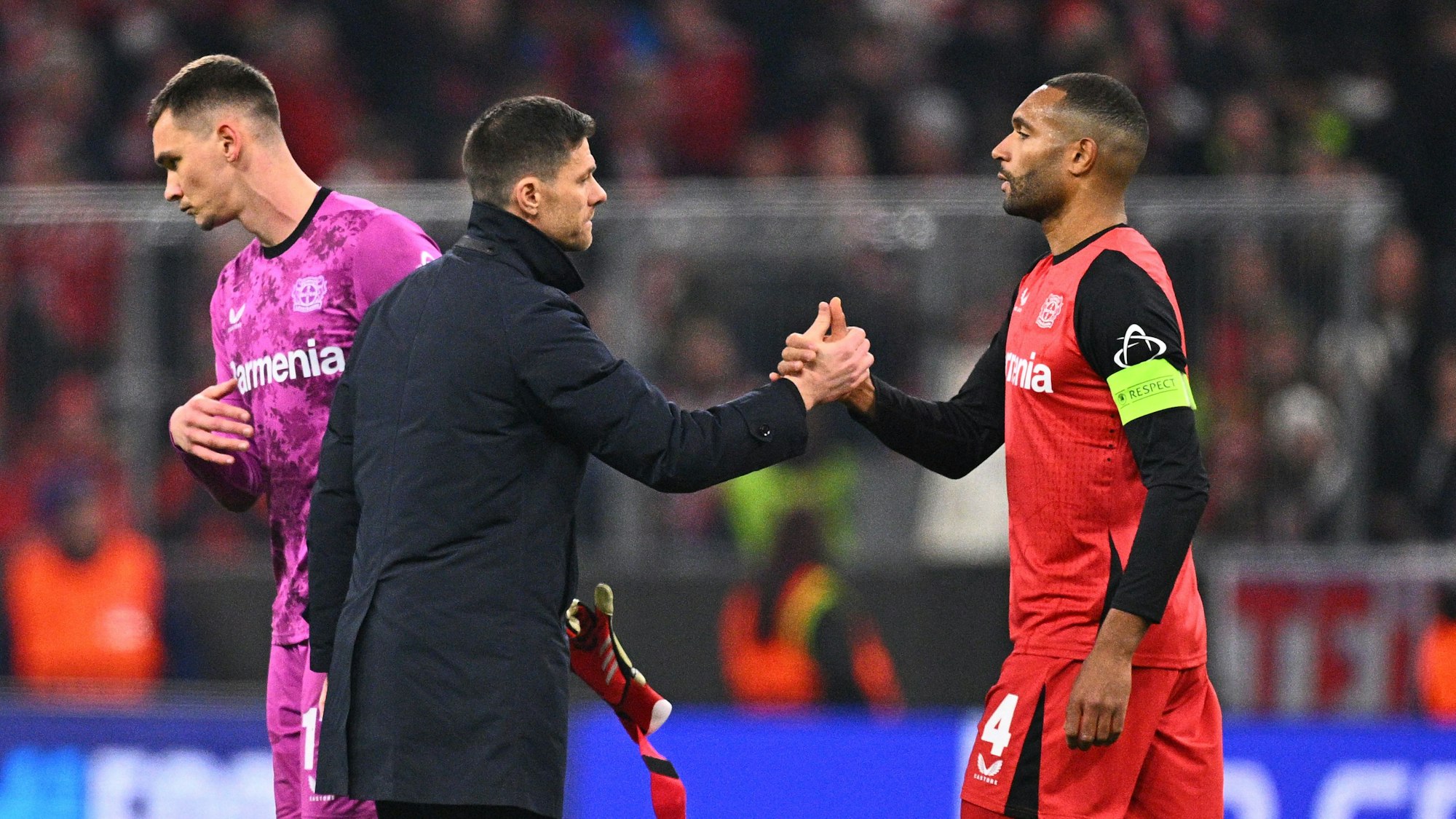Leverkusens Trainer Xabi Alonso (M) bedankt sich nach dem Spiel bei Torwart Matej Kovar (l) und Jonathan Tah.